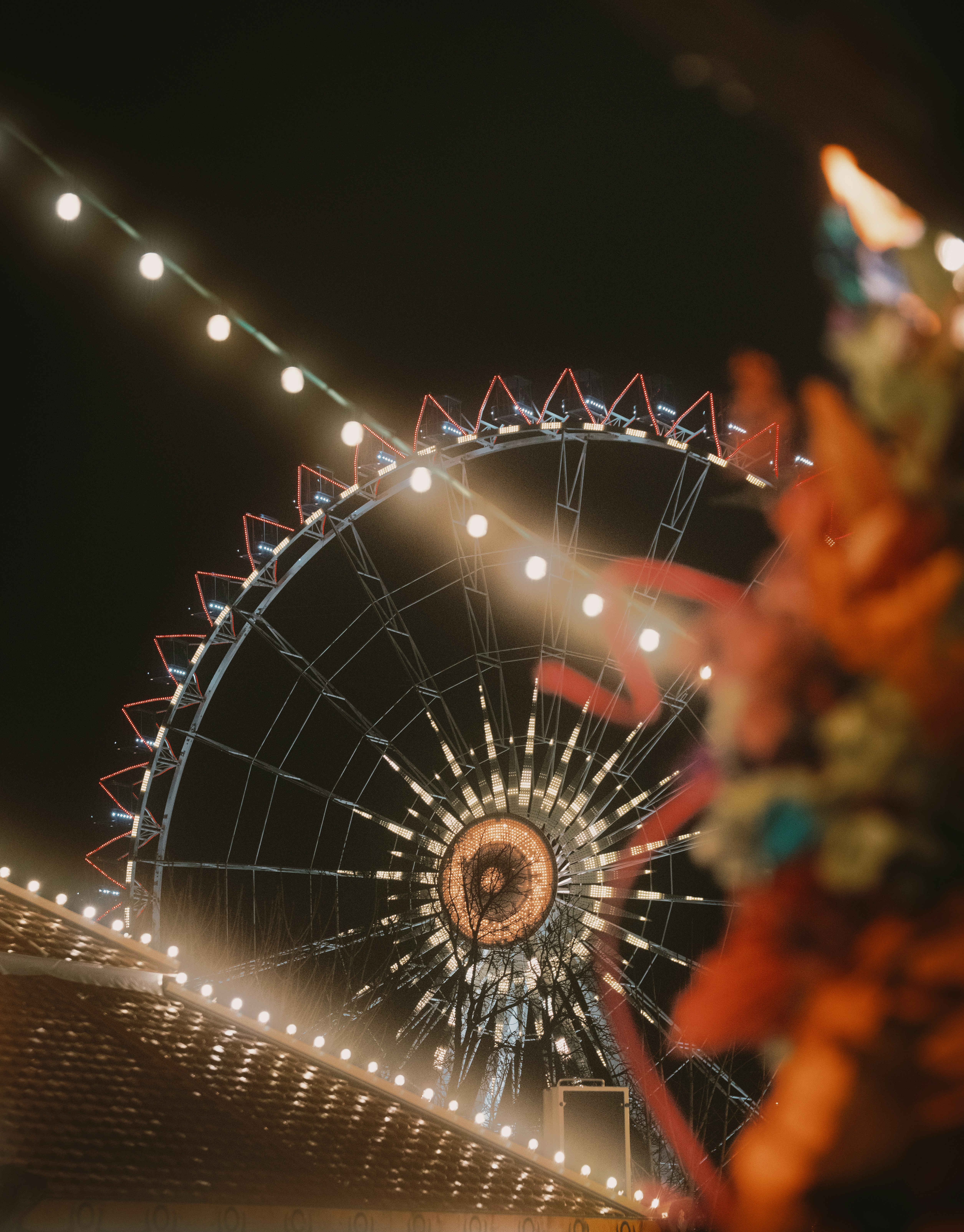 Ferris wheel illuminated at night with string lights