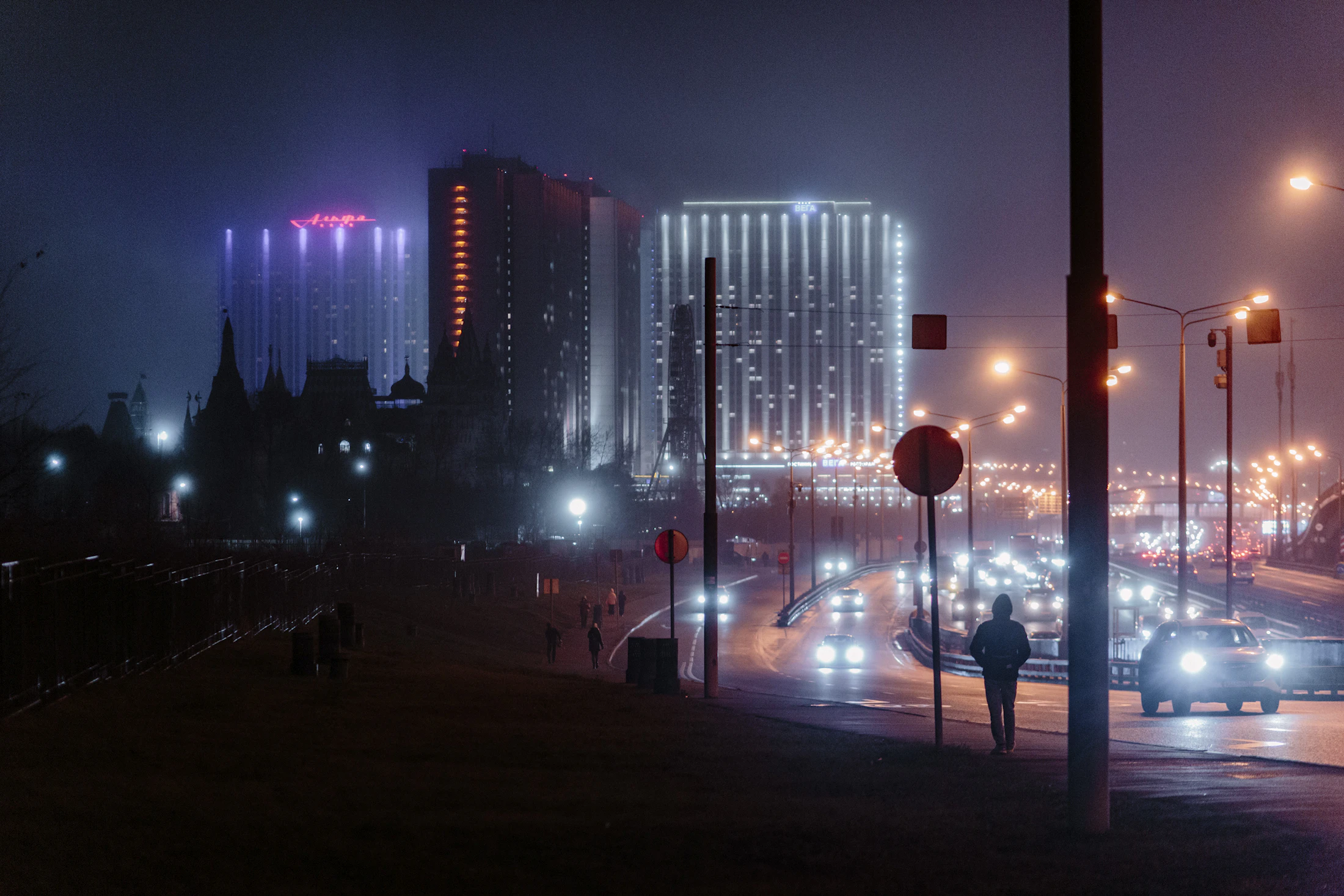 Moody cityscape at night with glowing buildings and streaking traffic light trails