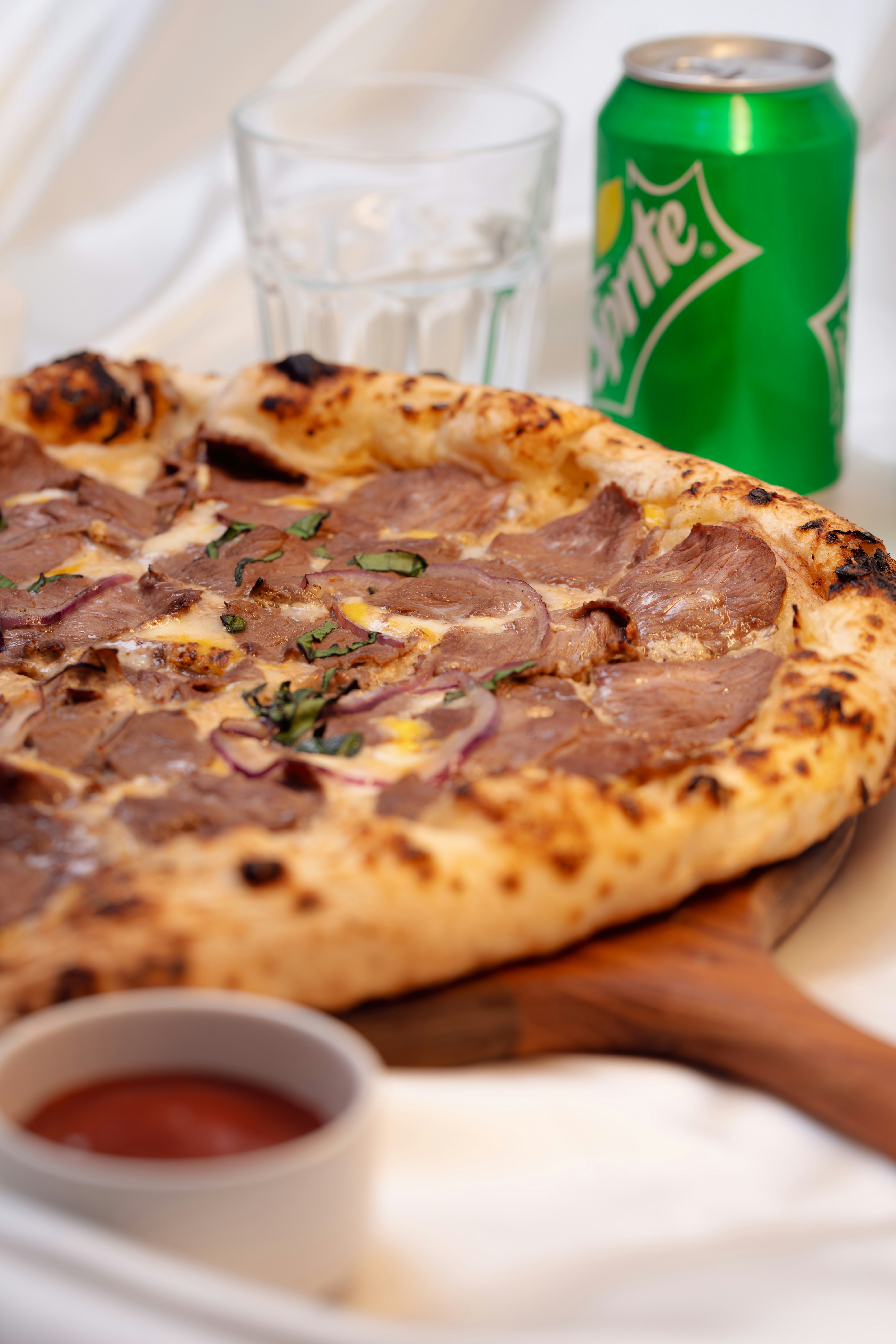 Pizza with meat, onions, and herbs, plus soda.