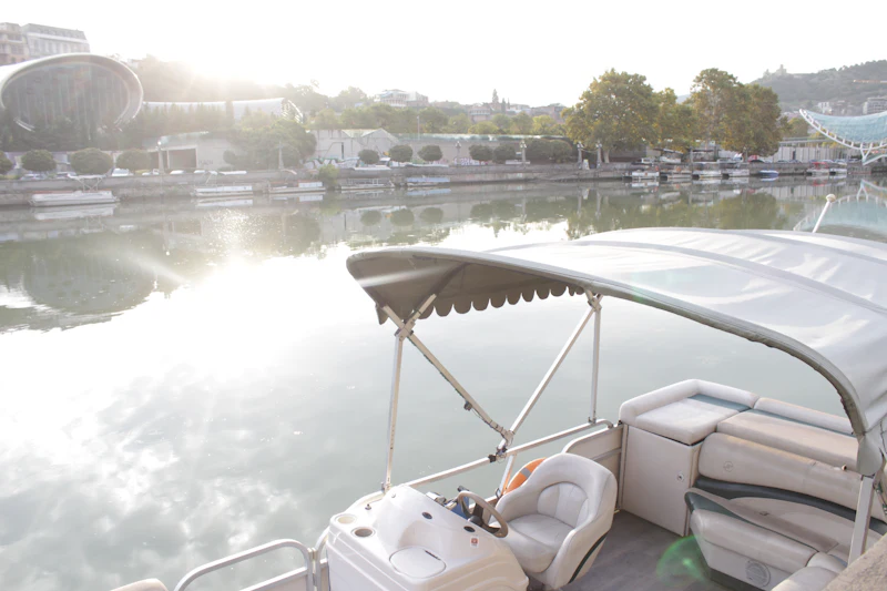 Pontoon boat on calm water at sunrise