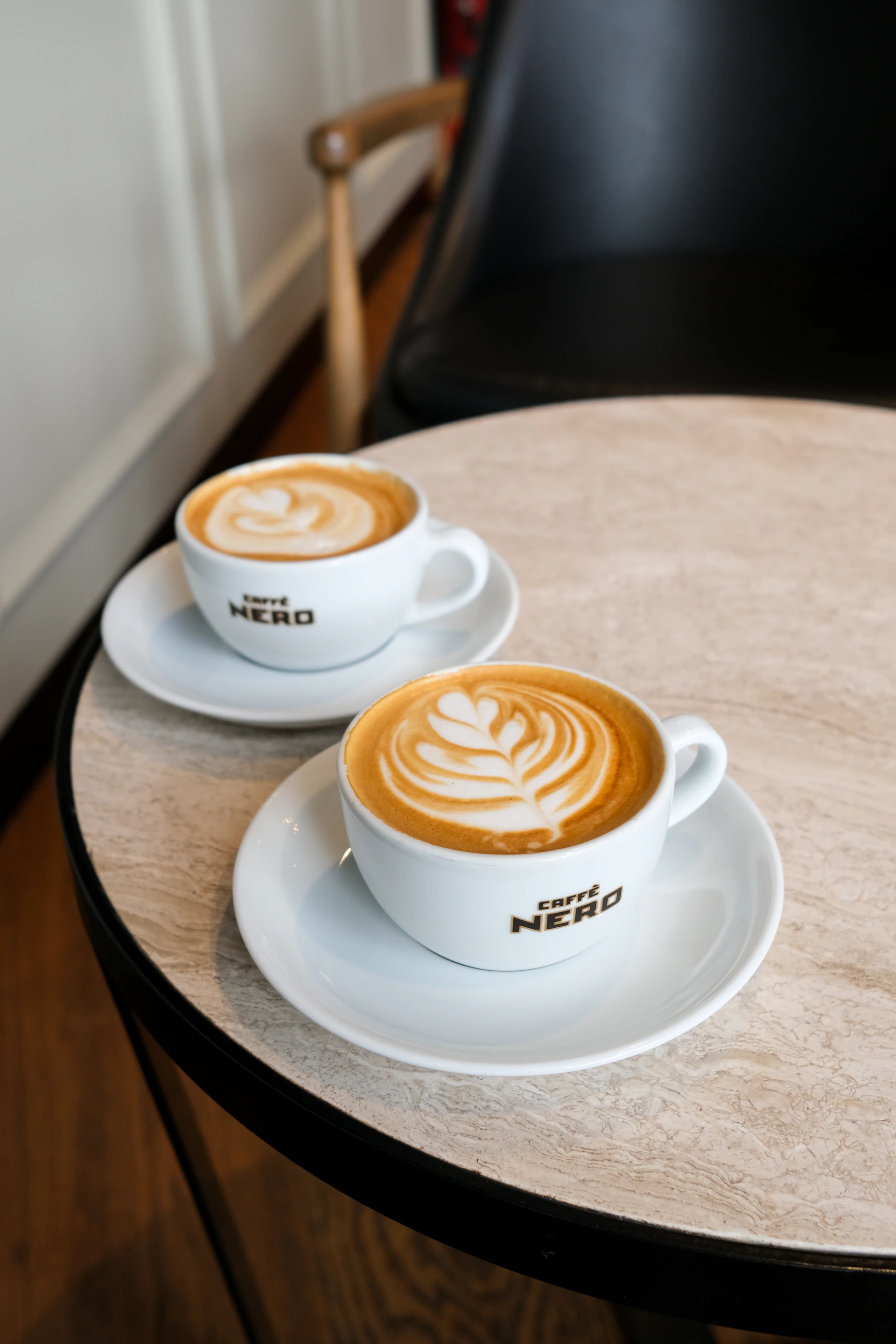 Two cups of latte art coffee on a table
