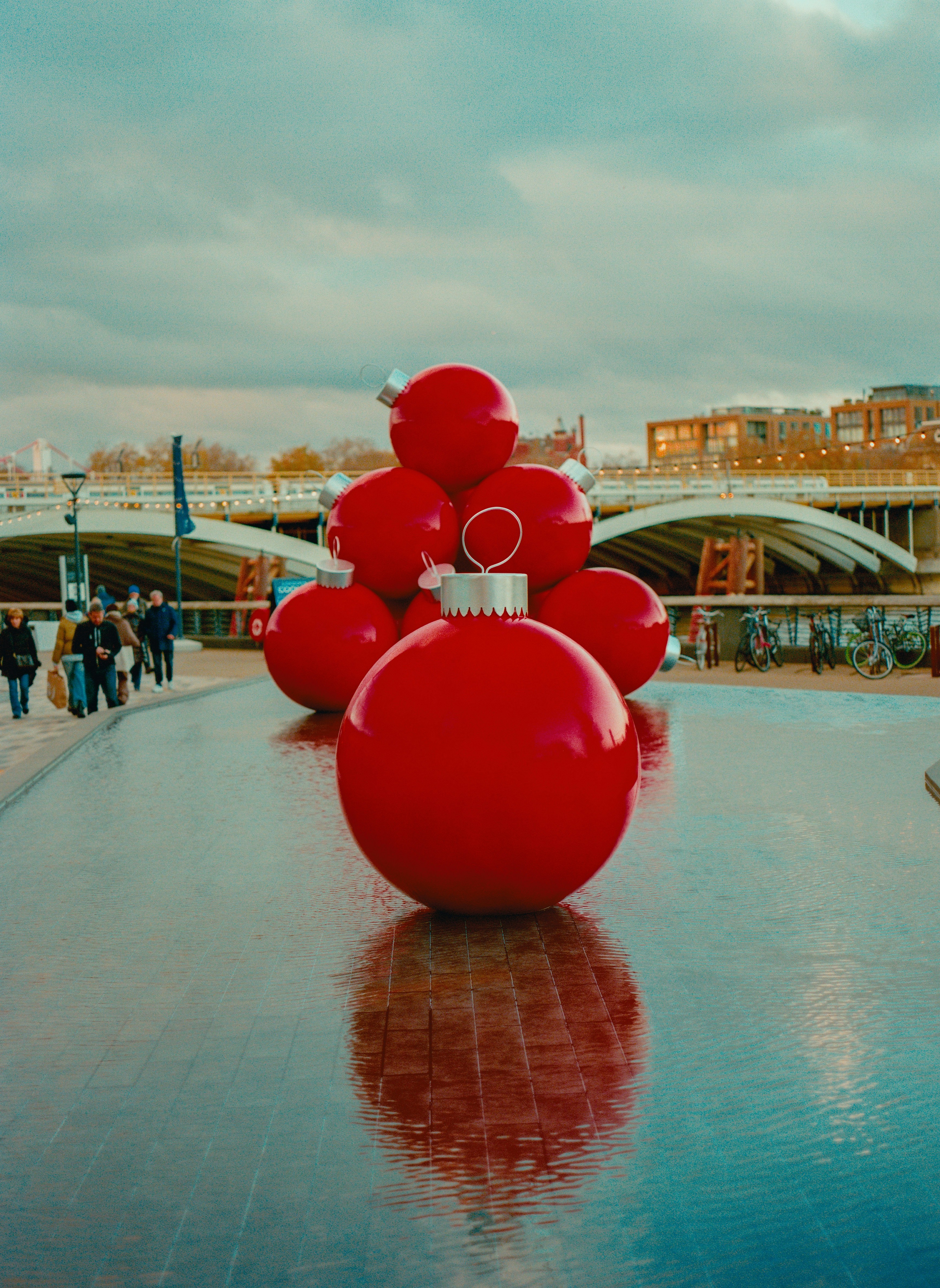 Giant red christmas ornaments reflected in water