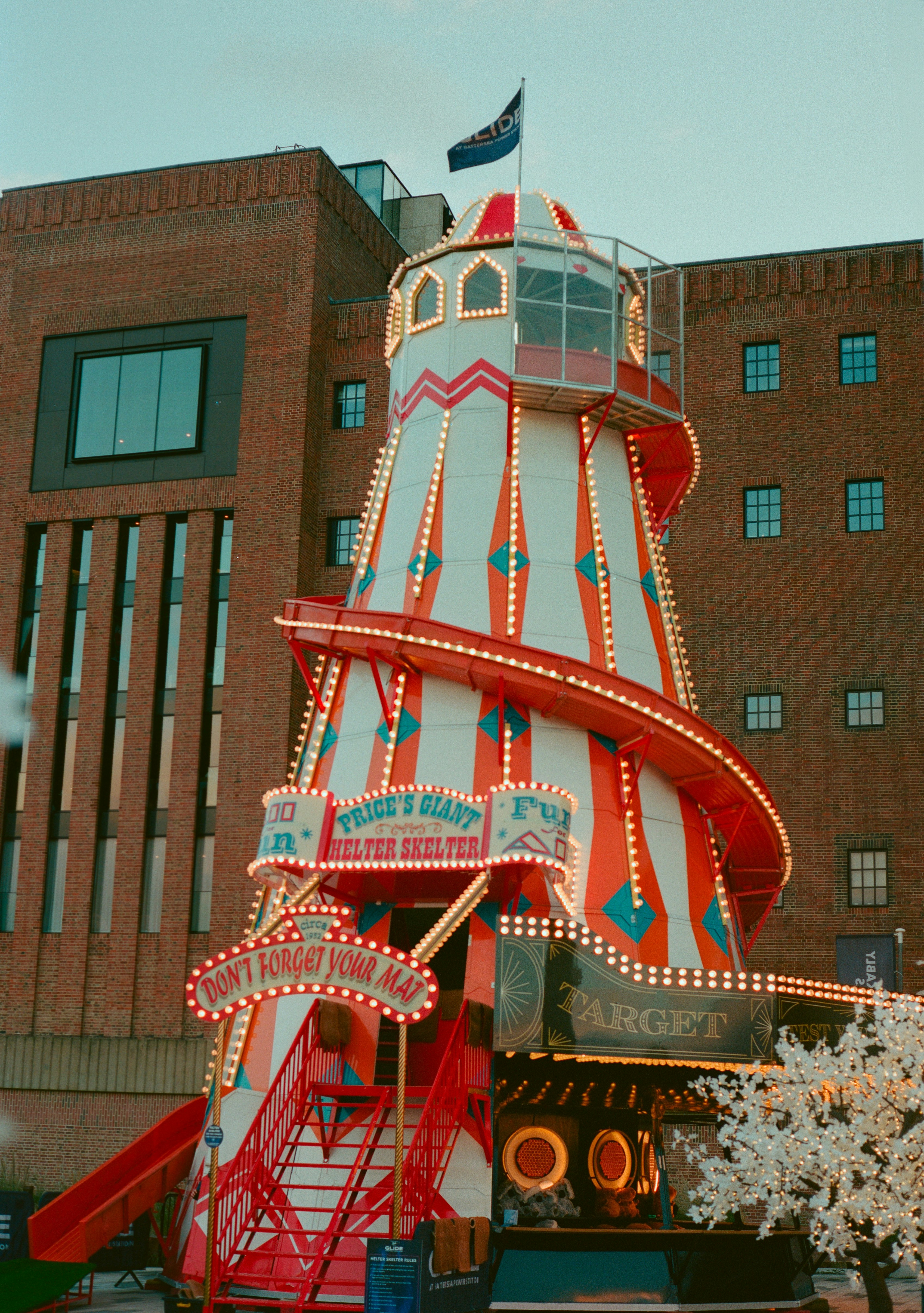 A brightly lit carnival ride with a slide.
