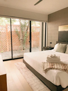 Bedroom with large glass doors opening to a courtyard.