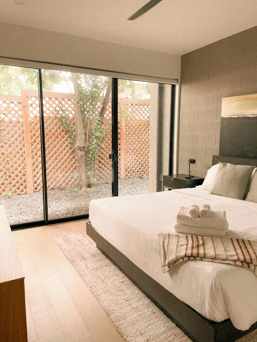 Bedroom with large glass doors opening to a courtyard.