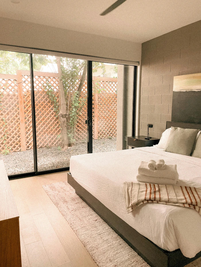 Premium bedroom with custom-installed glass sliding doors opening to a courtyard