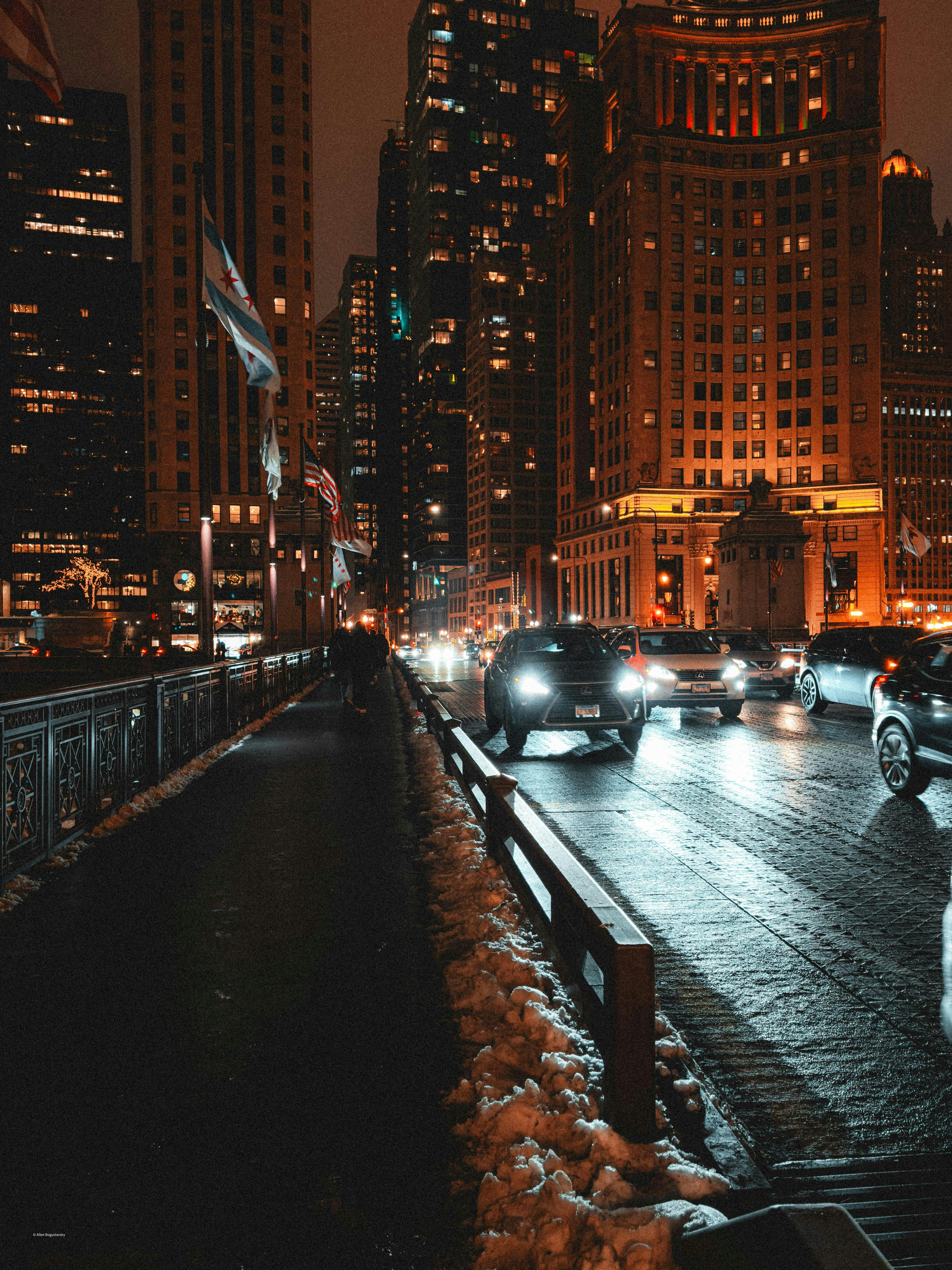 밤에 젖은 도시 거리에서 자동차가 달리고 있습니다.