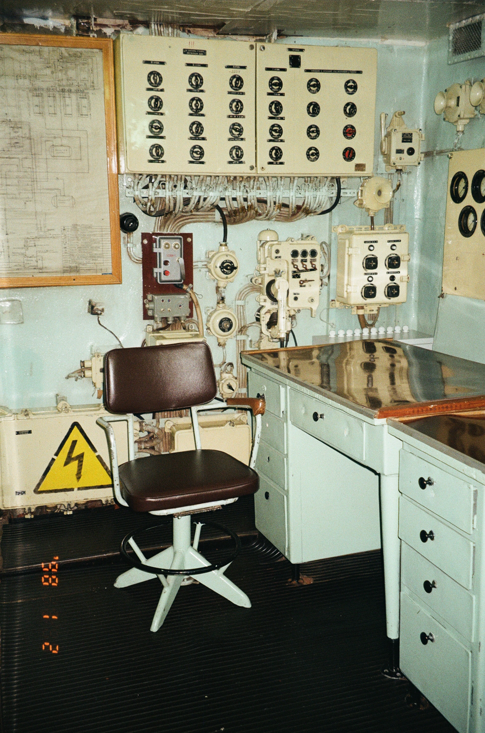 Control room with desk, chair, and electrical panels