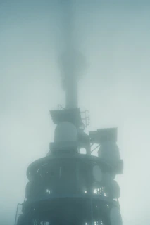 Towering communication tower shrouded in thick fog.