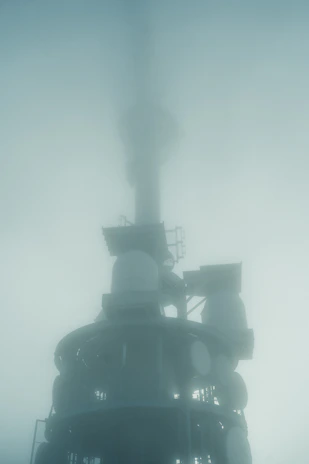 Towering communication tower shrouded in thick fog.