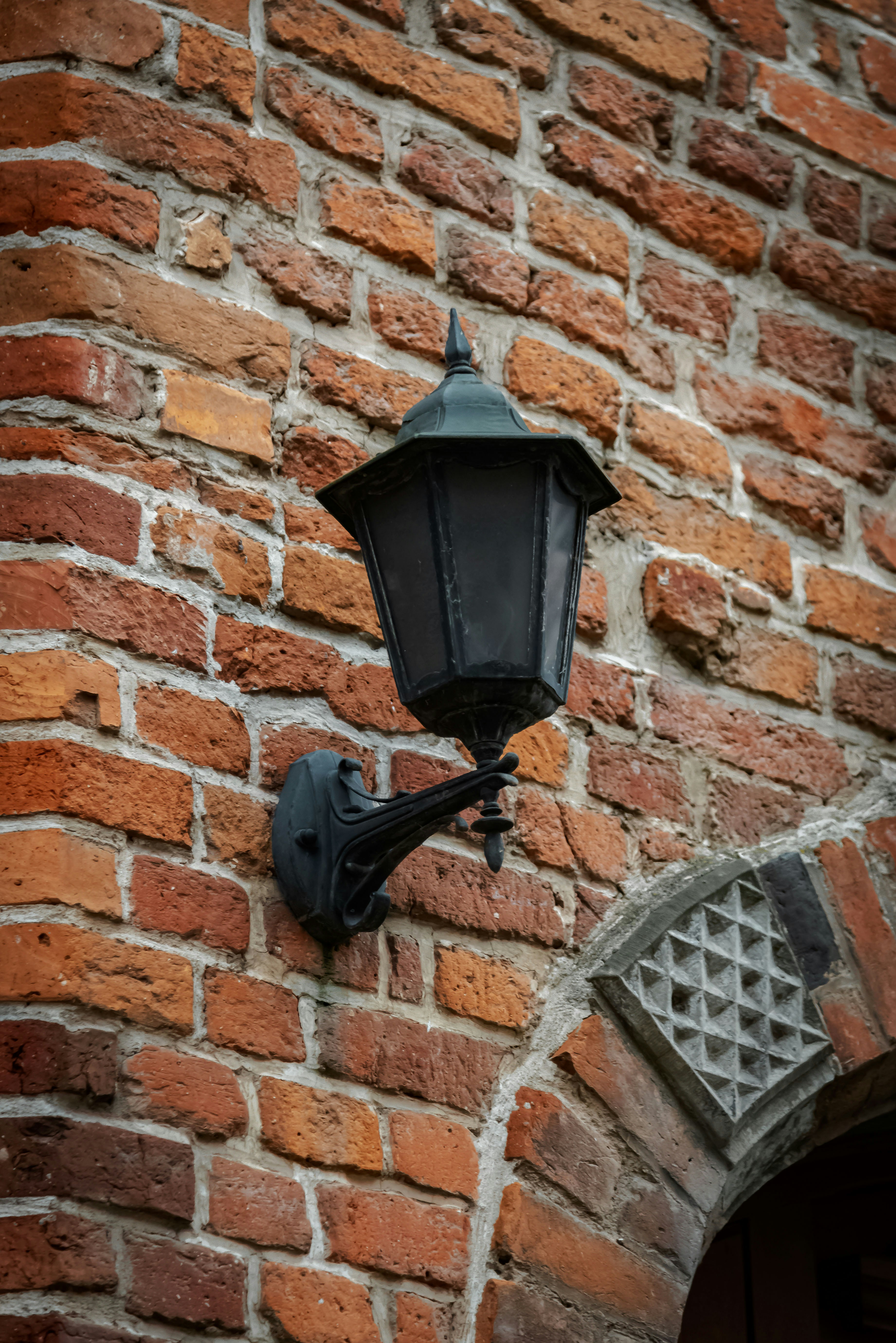 Black lantern mounted on a brick wall