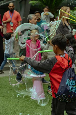 Children playing with large soap bubbles outdoors