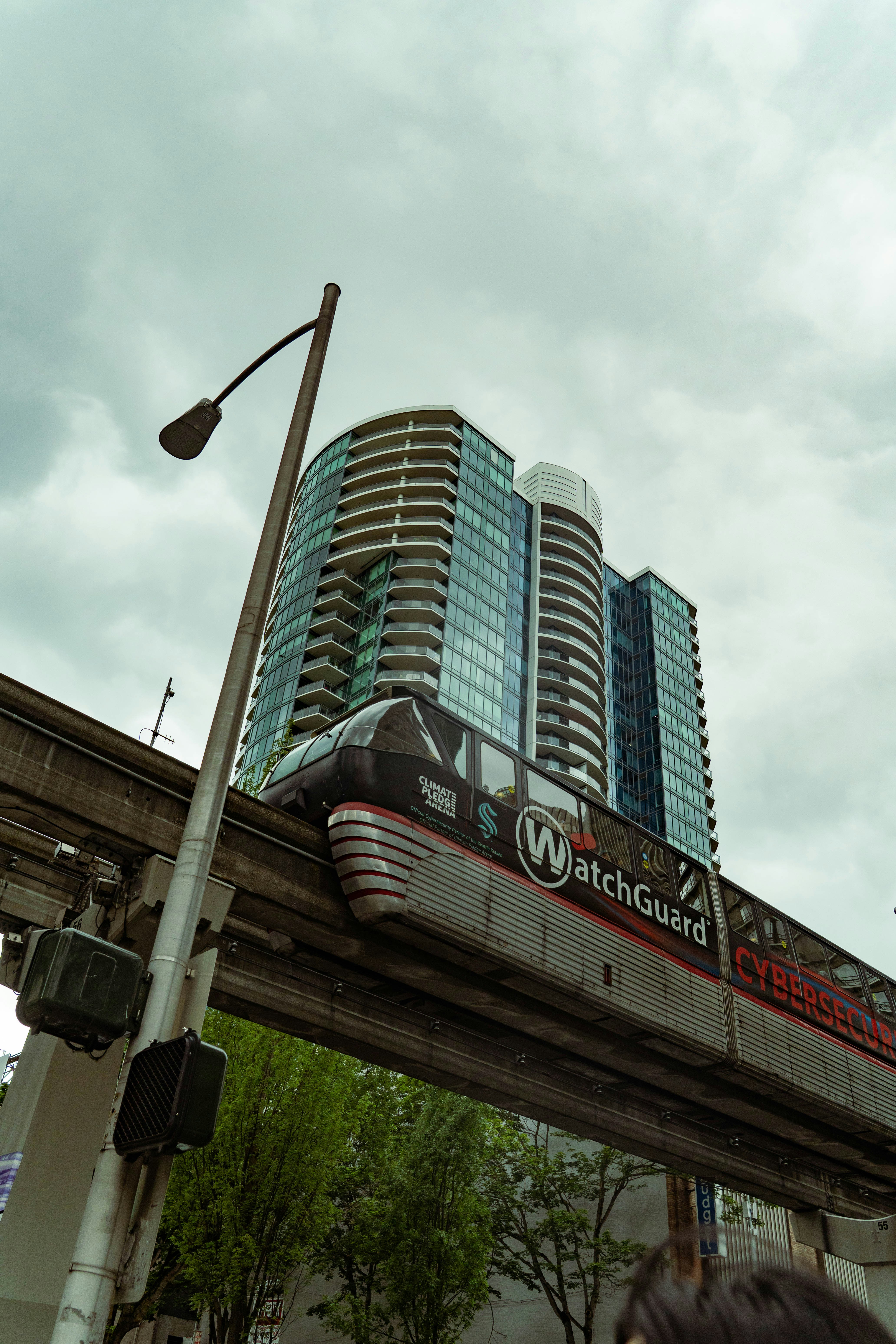 Monorail train passes modern glass building
