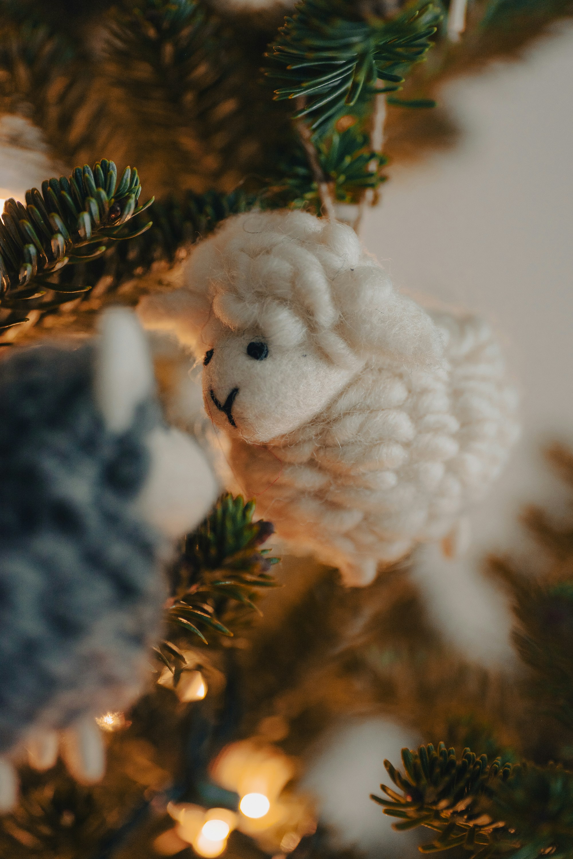 Felt sheep ornament on a christmas tree.