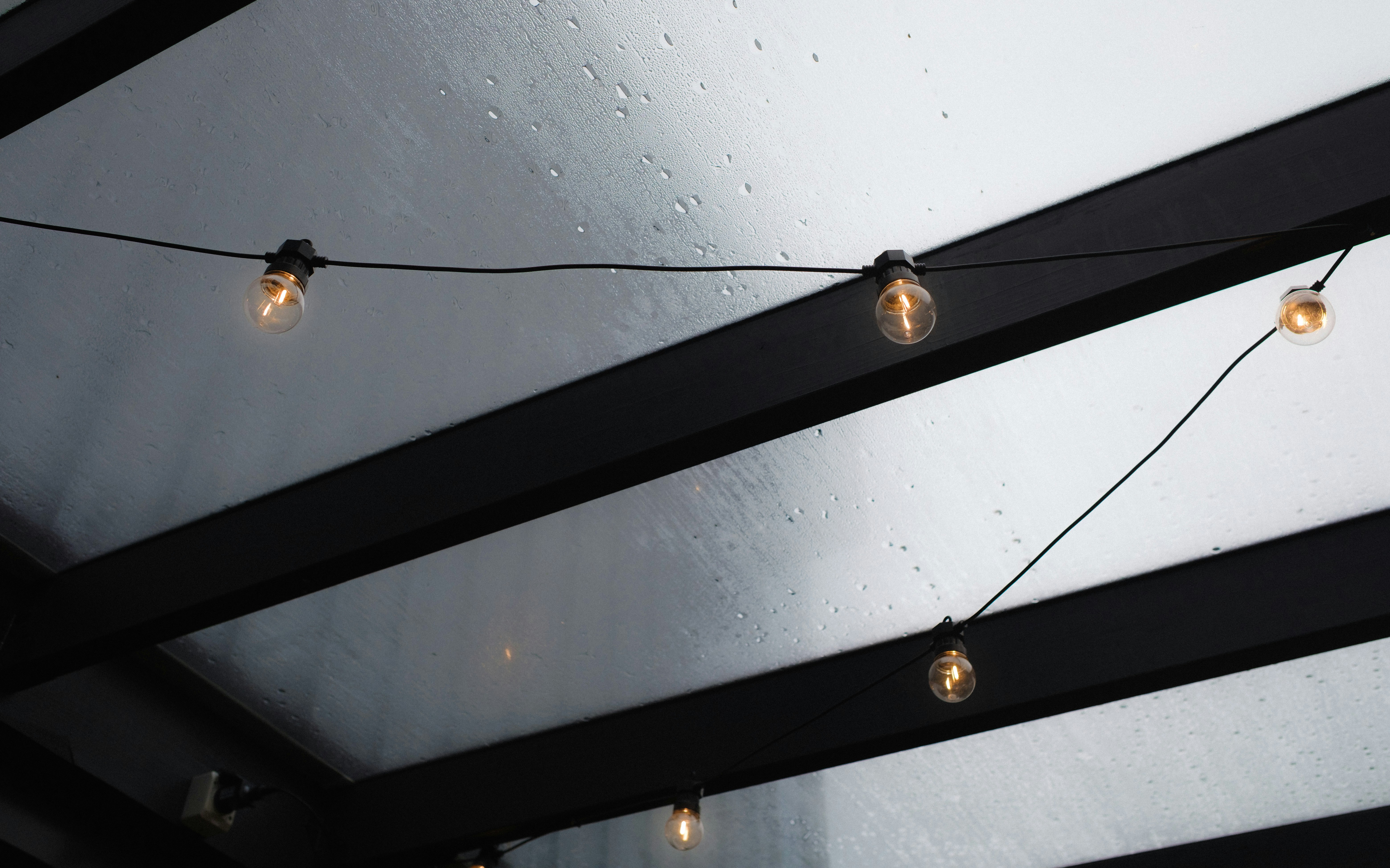 String lights hang under a clear roof
