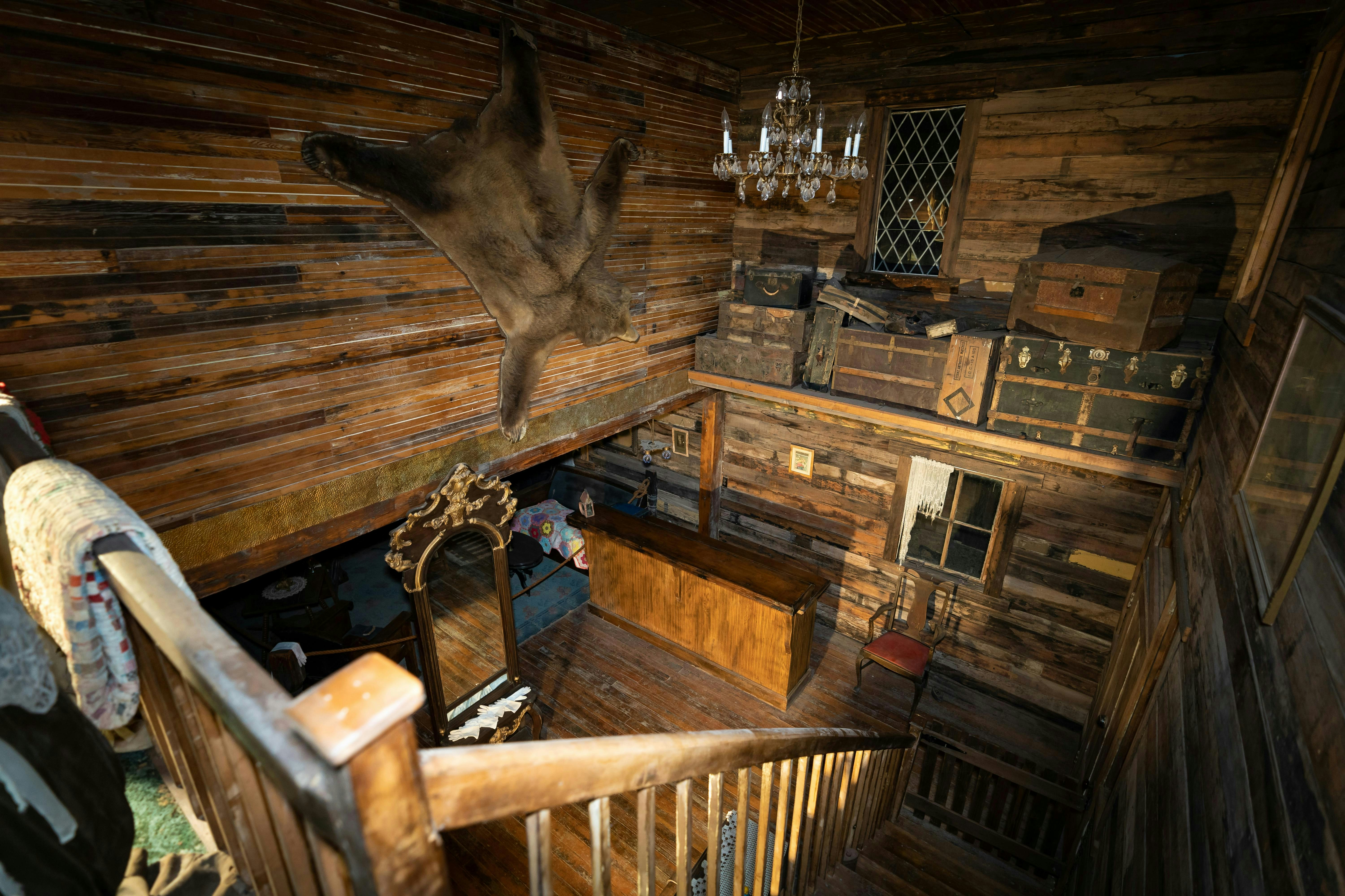 Rustic wooden interior with hanging animal pelt and chandelier.