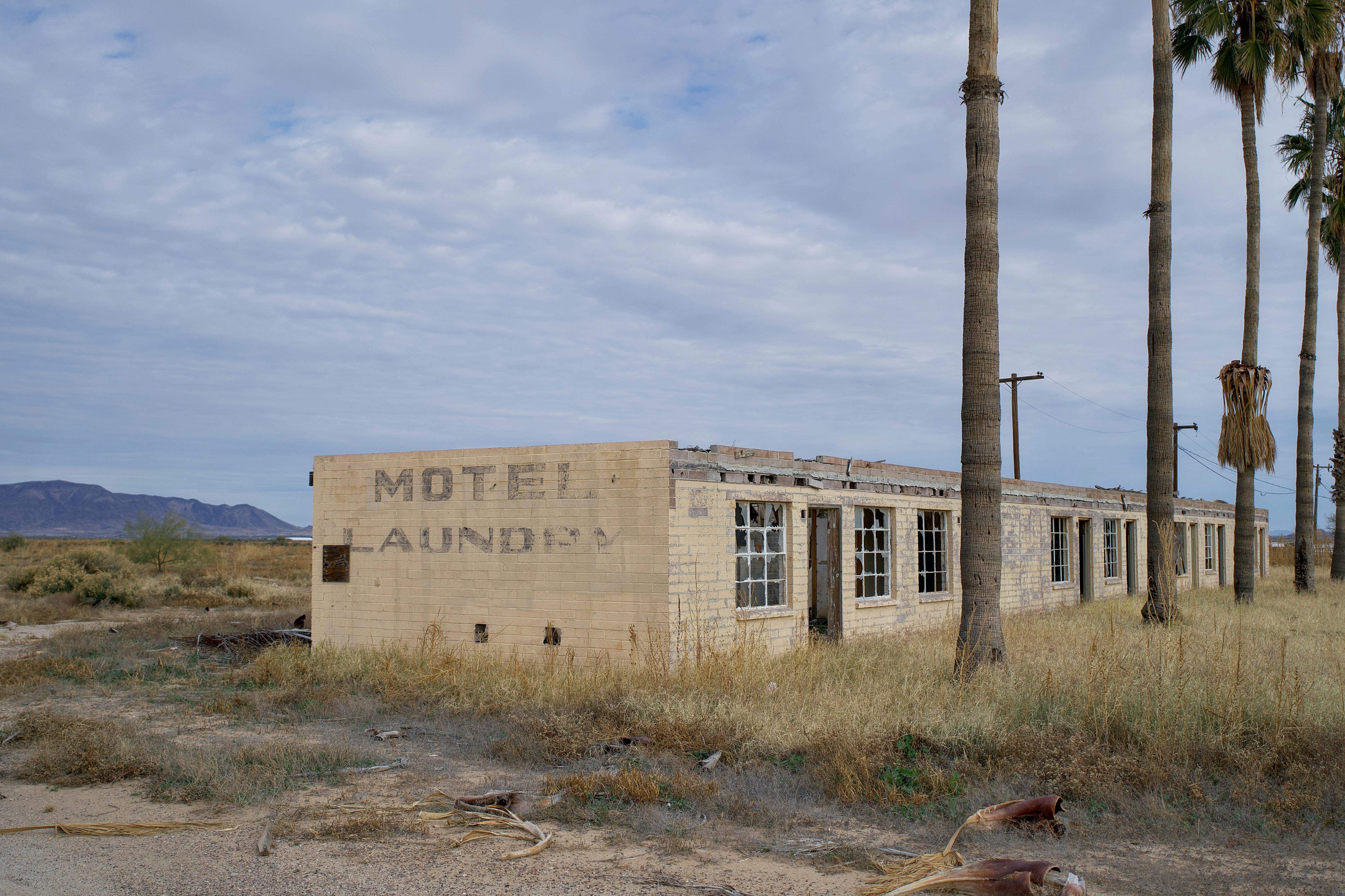 Abandoned motel with laundry sign and palm trees