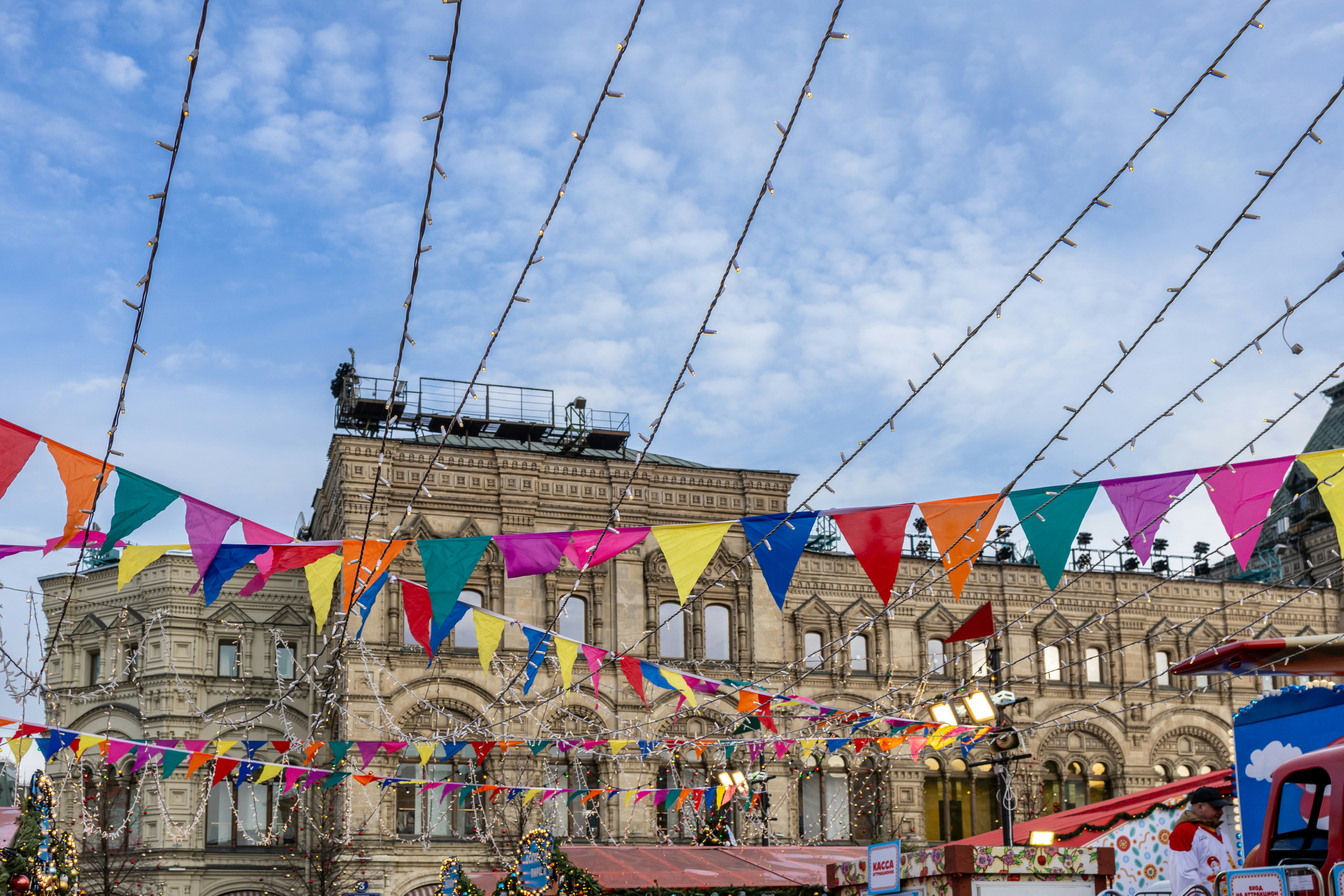Colorful festive flags hang in front of a grand building.