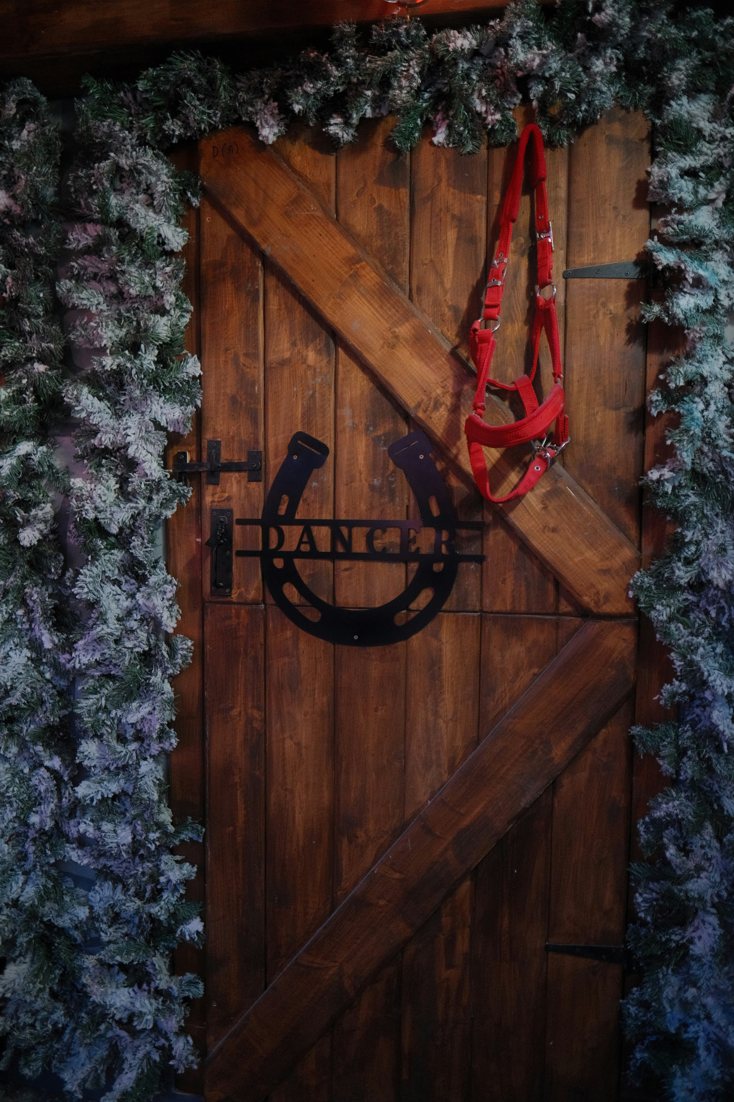 Puerta de granero de madera con herradura y decoración de brida