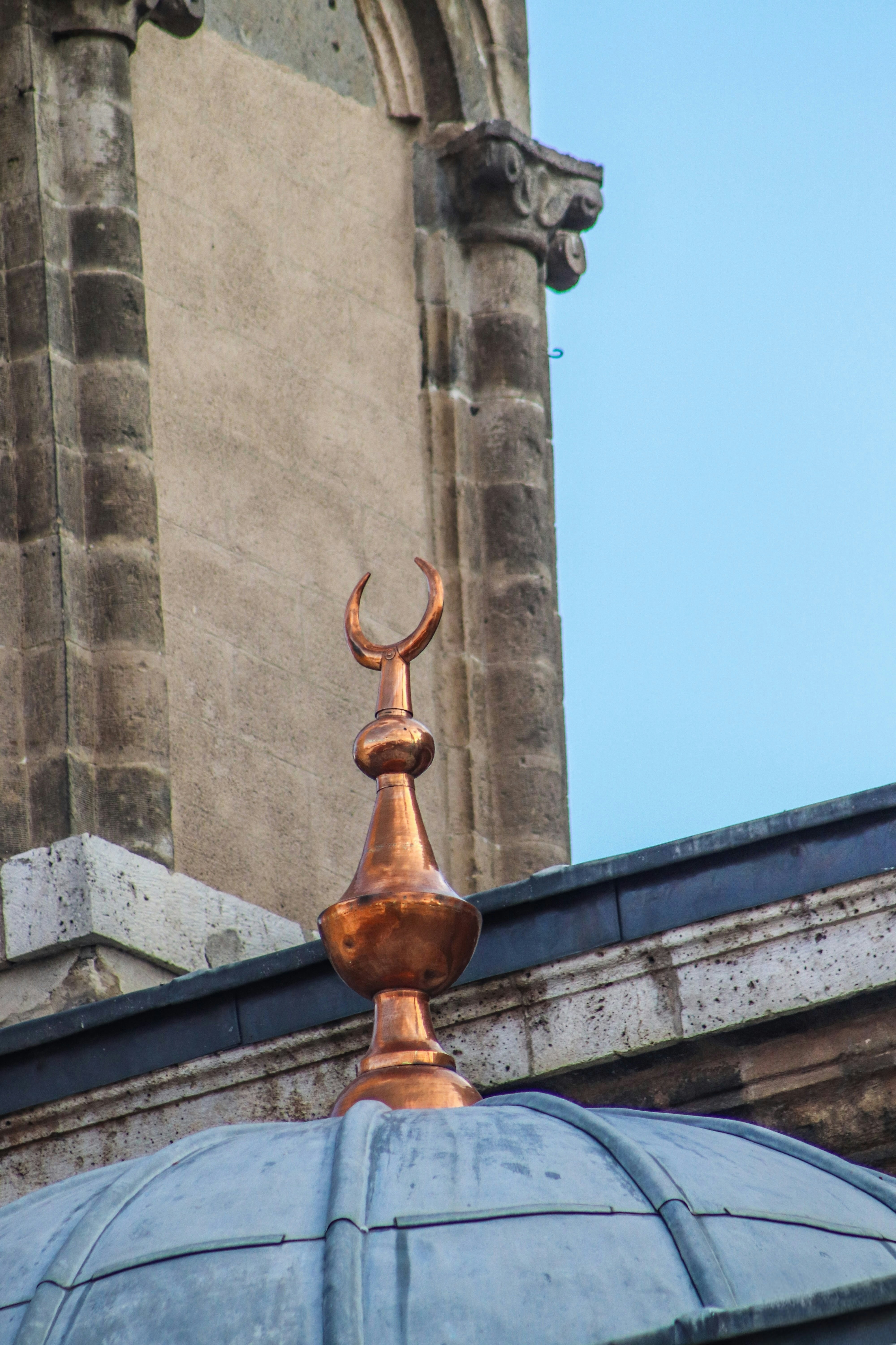 A copper crescent moon atop a mosque dome