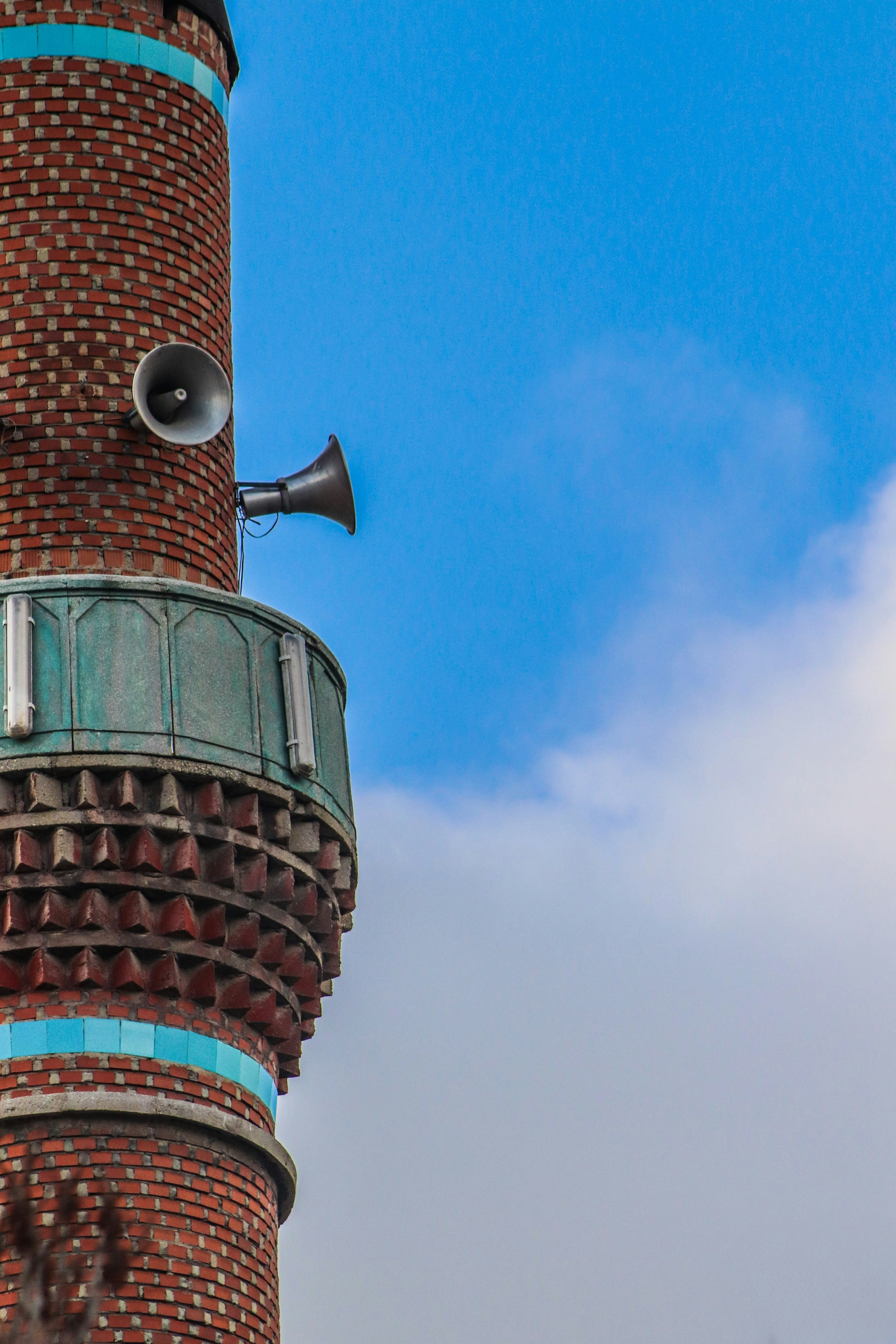 Minaret with speakers against a blue sky