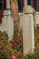 Ornate gravestones with arabic inscriptions in a garden