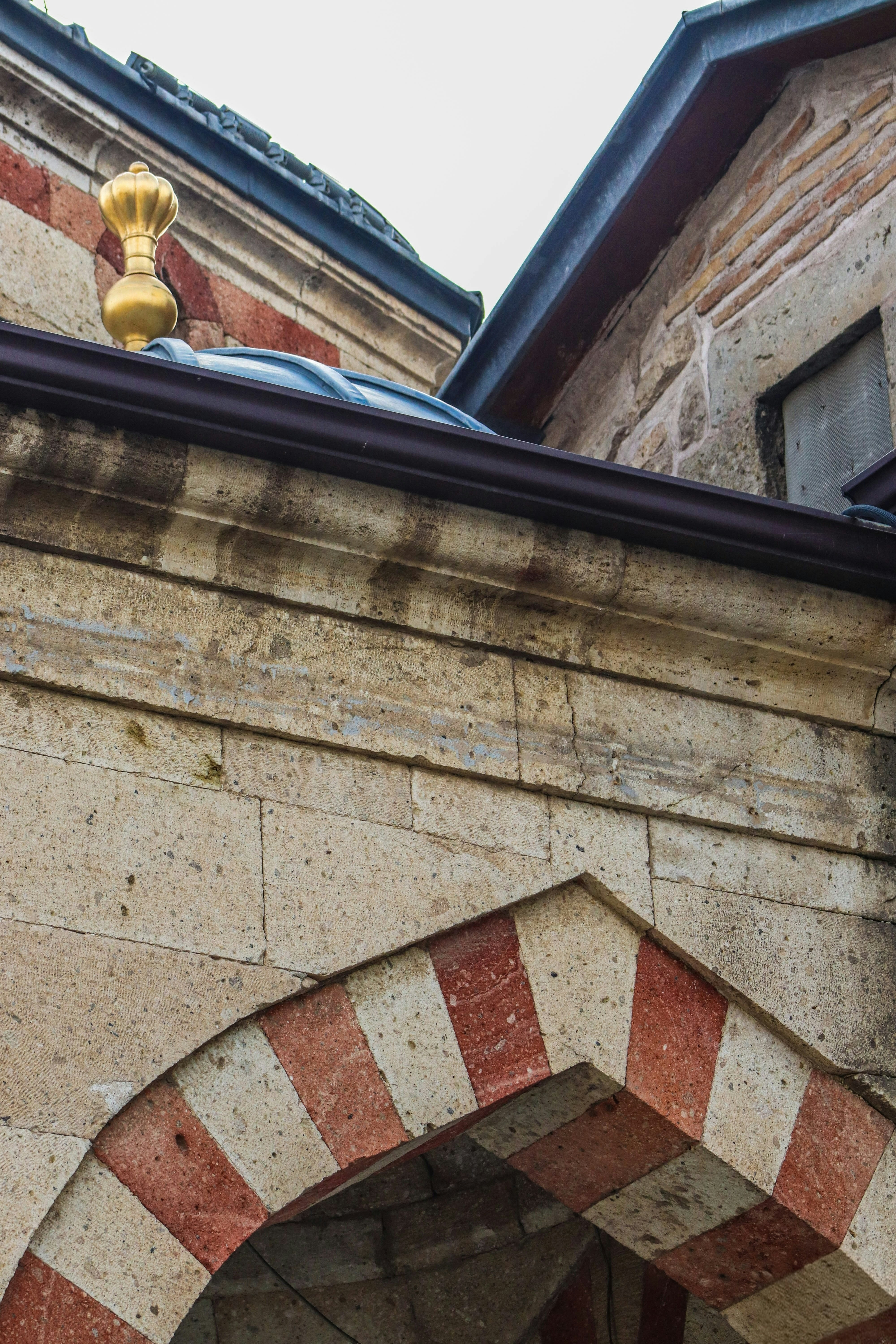 Close-up of an ornate archway with red and white stripes.