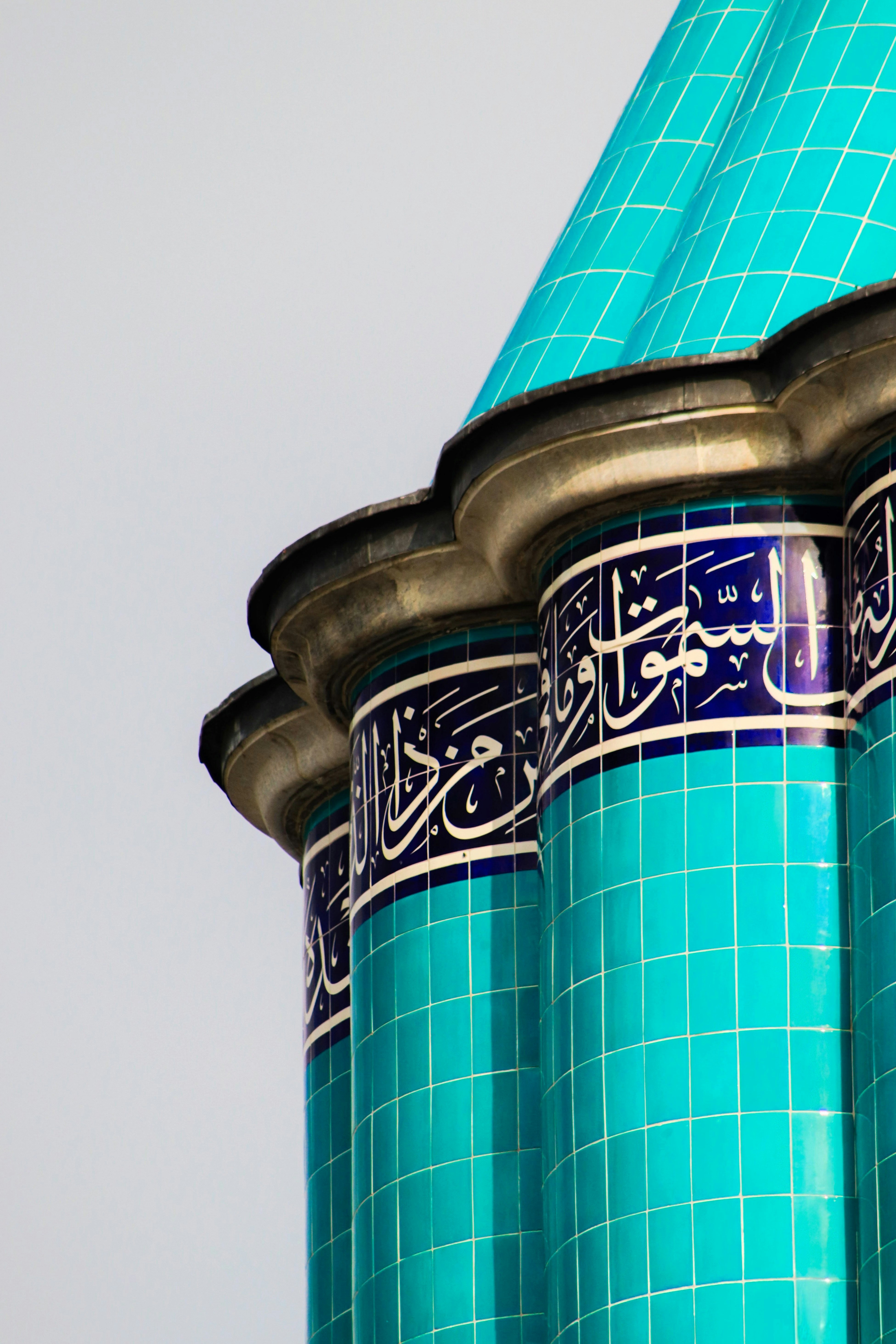 Turquoise tiled columns with arabic calligraphy