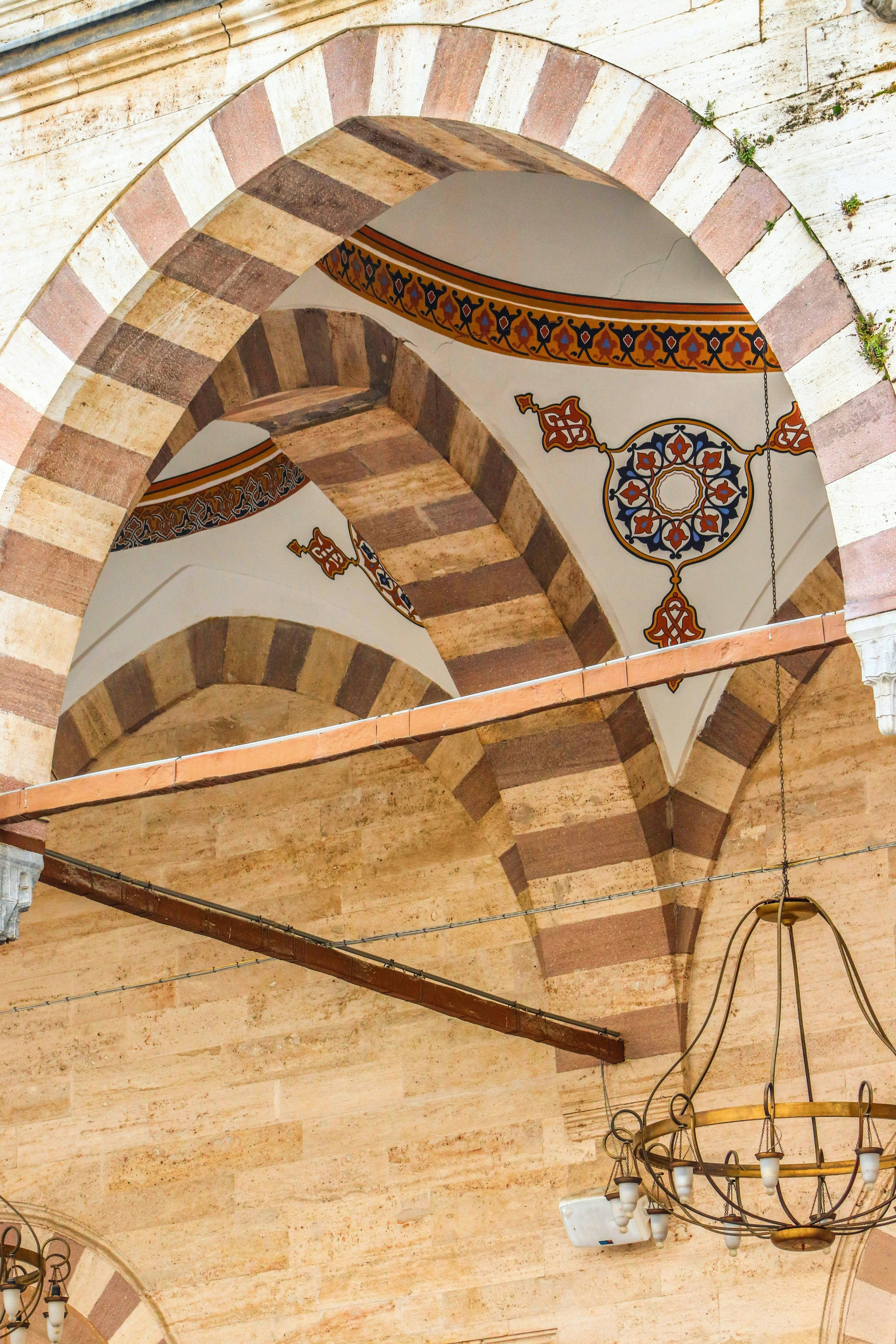 Arched entryway with ornate ceiling details and chandelier