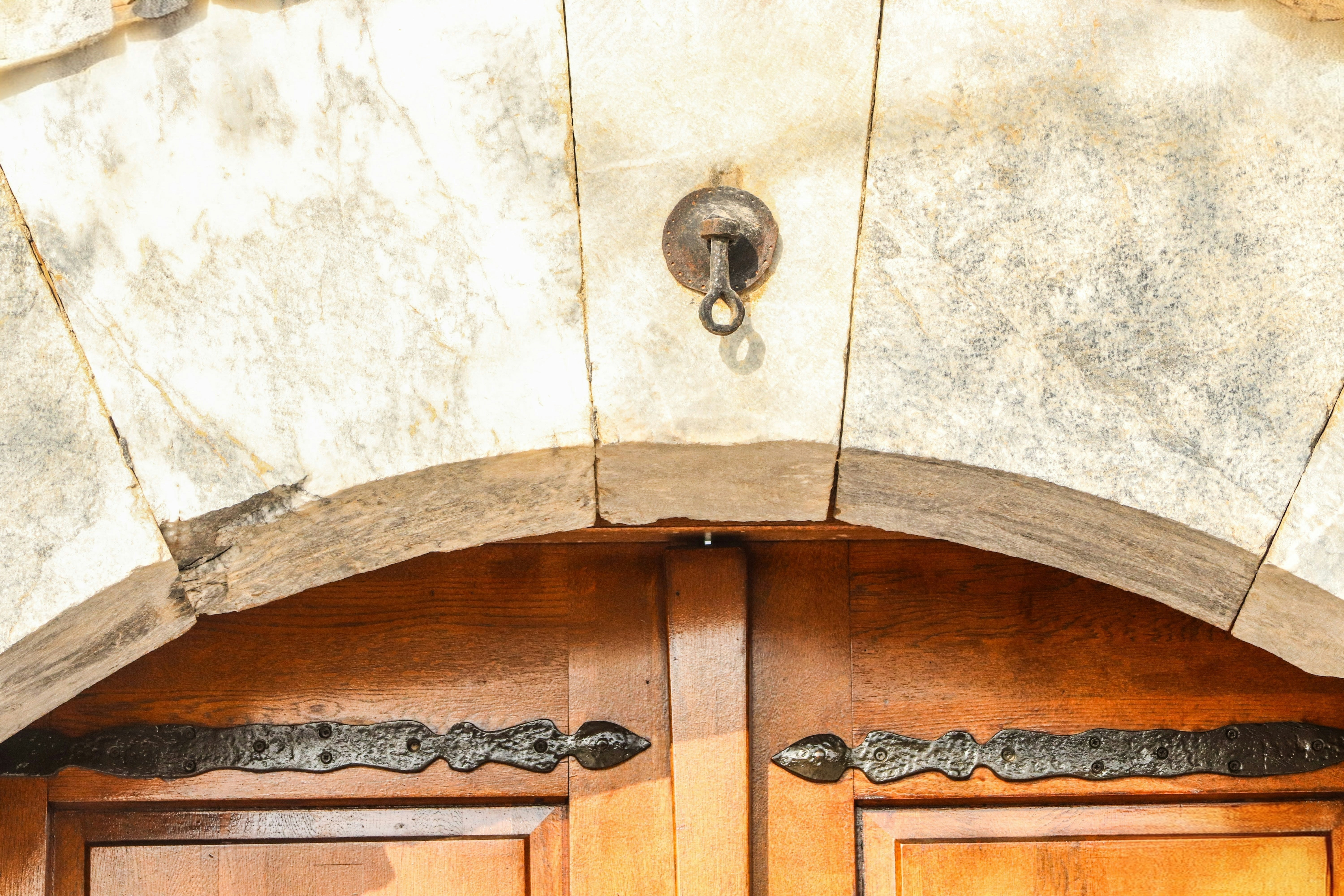 Close-up of an old wooden door with ornate hinges.