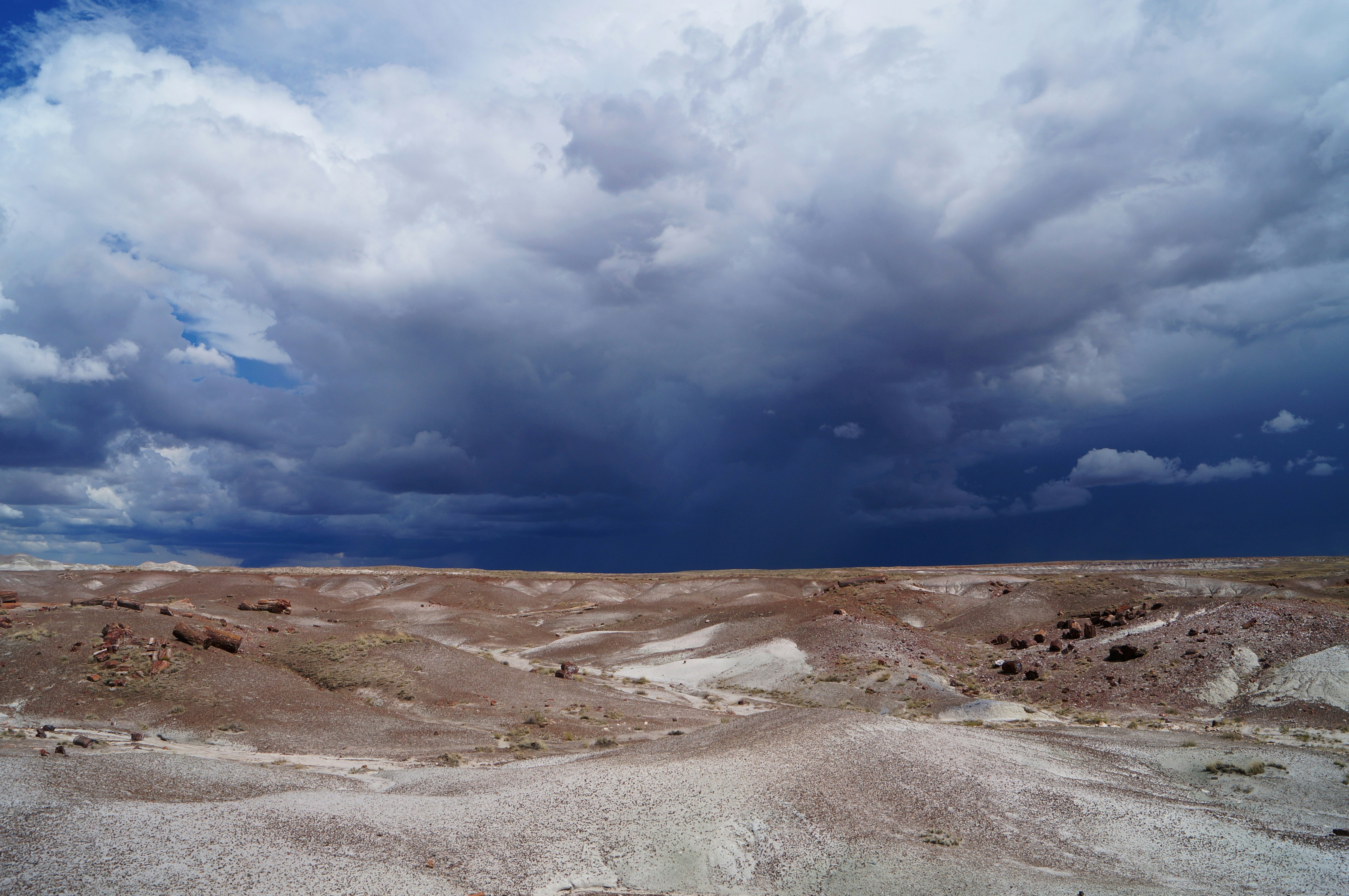 Dramatic storm clouds gather over arid desert landscape