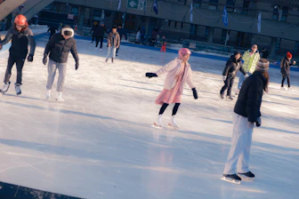People ice skating on an outdoor rink.