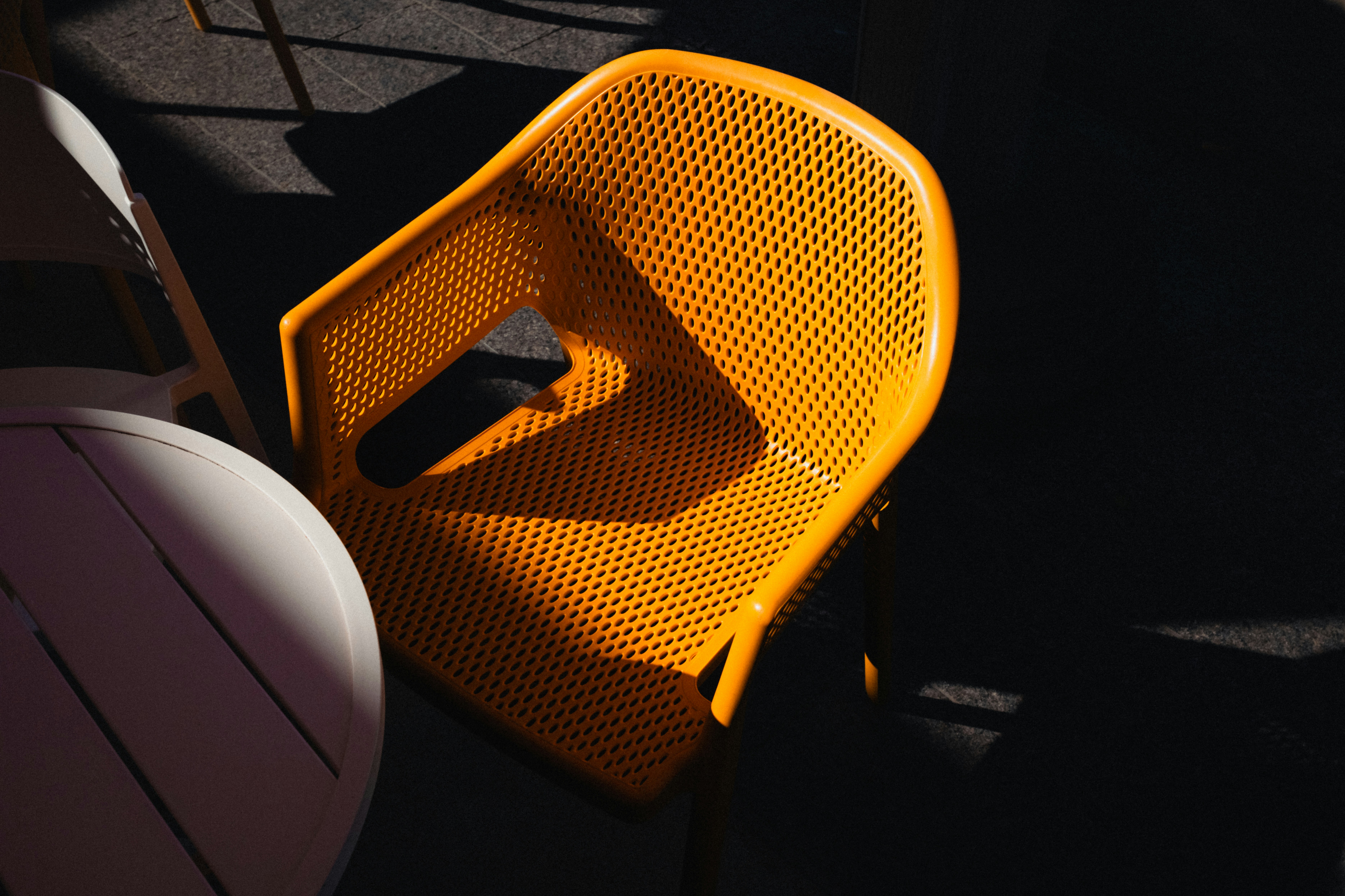 A bright yellow chair casting a shadow