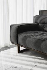 A modern grey sofa with wooden legs.