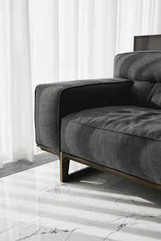 A modern grey sofa with wooden legs.