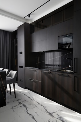 Modern dark kitchen with marble floor and countertops