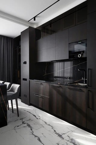 Modern dark kitchen with marble floor and countertops