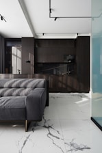 Modern living room with dark kitchen and marble floor