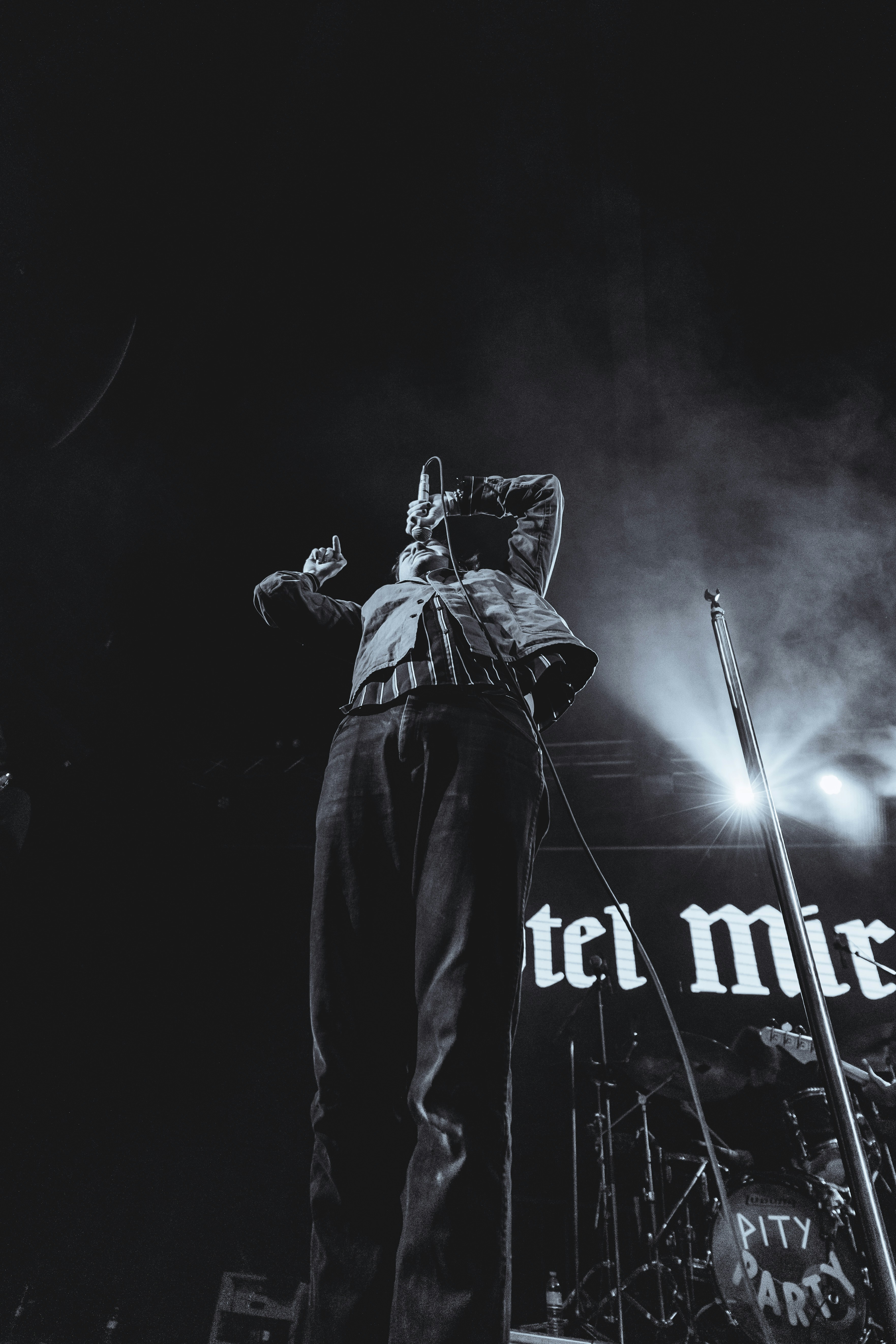 Un cantante si esibisce sul palco con luci intense.