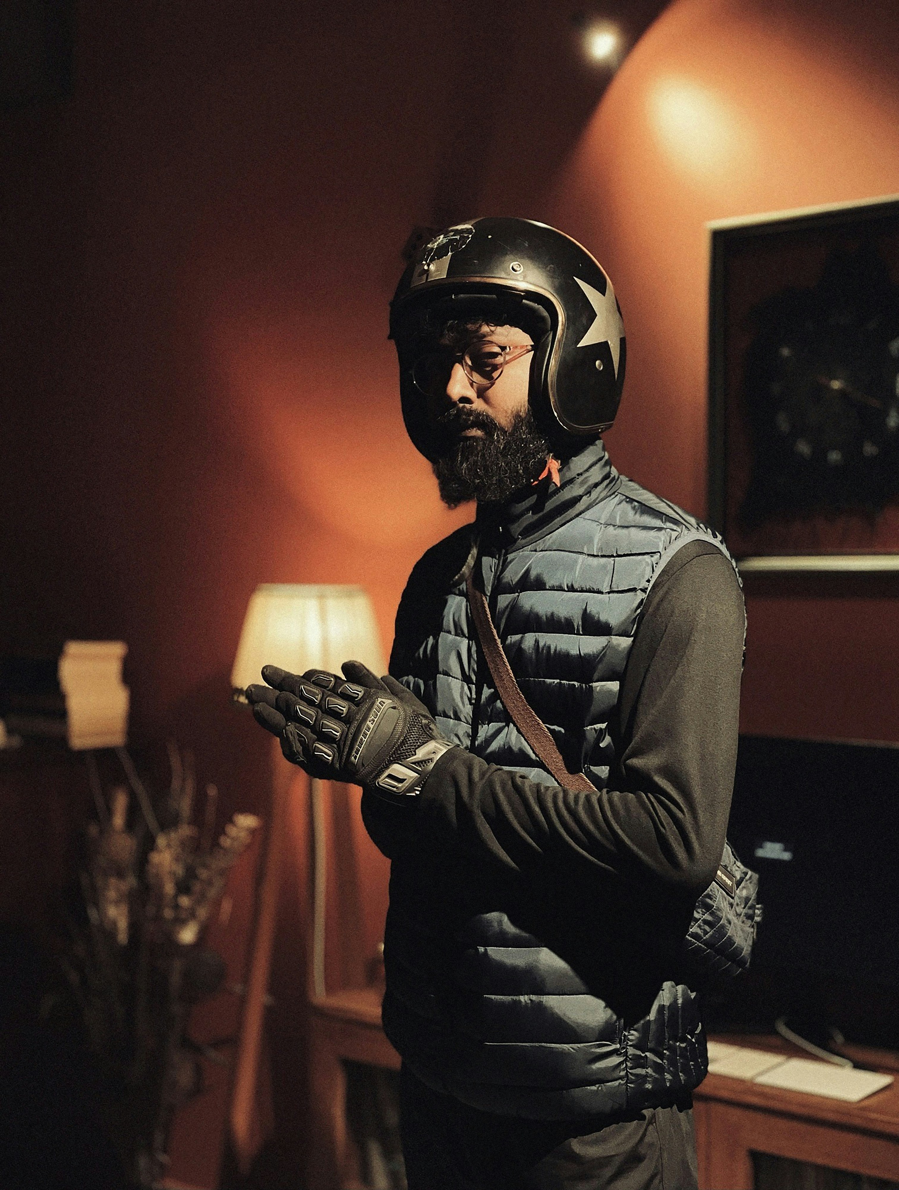 Man wearing helmet and gloves, indoors.