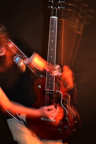 Person playing an electric guitar with motion blur.