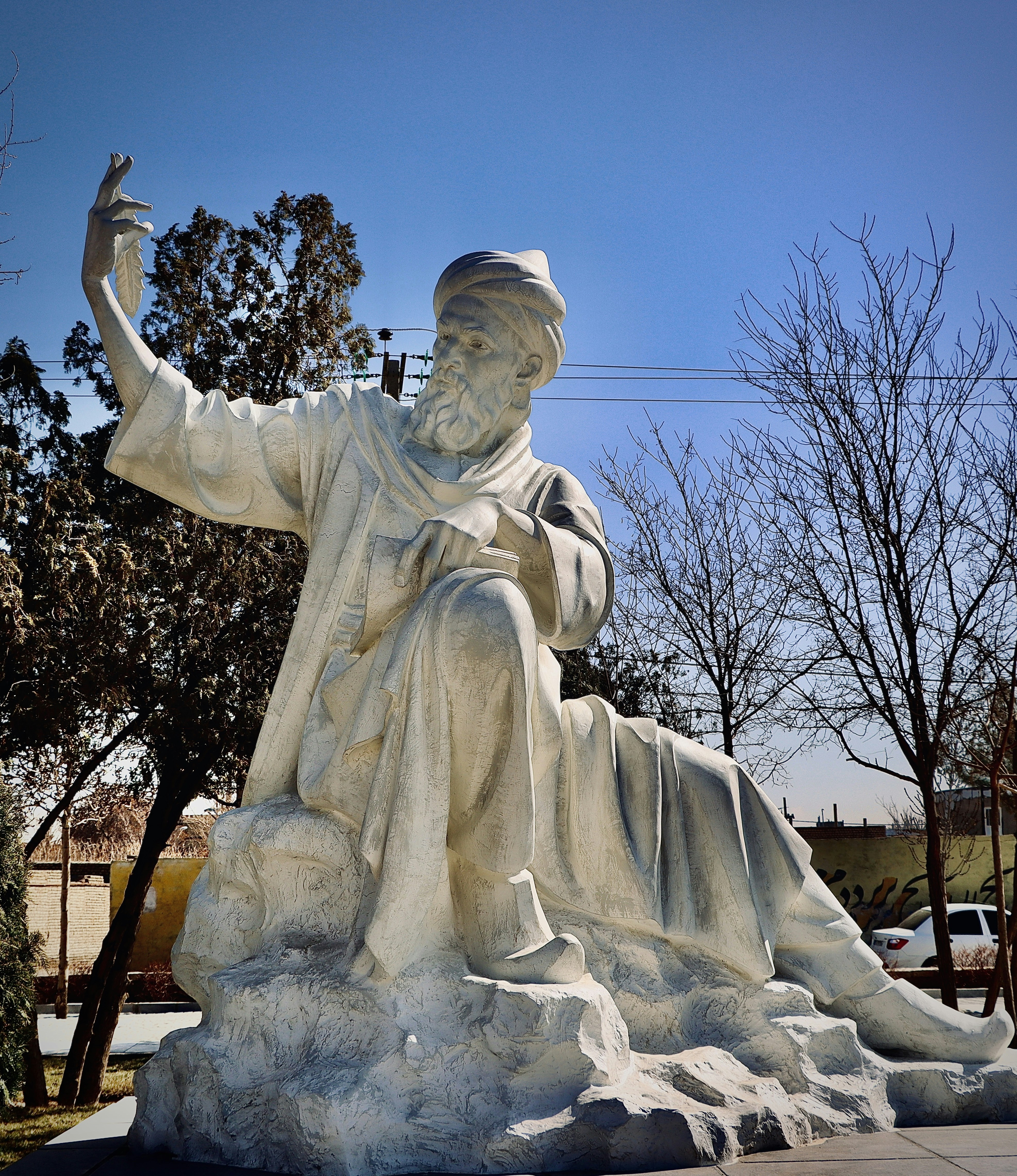 Une statue assise d’un homme en habits traditionnels.
