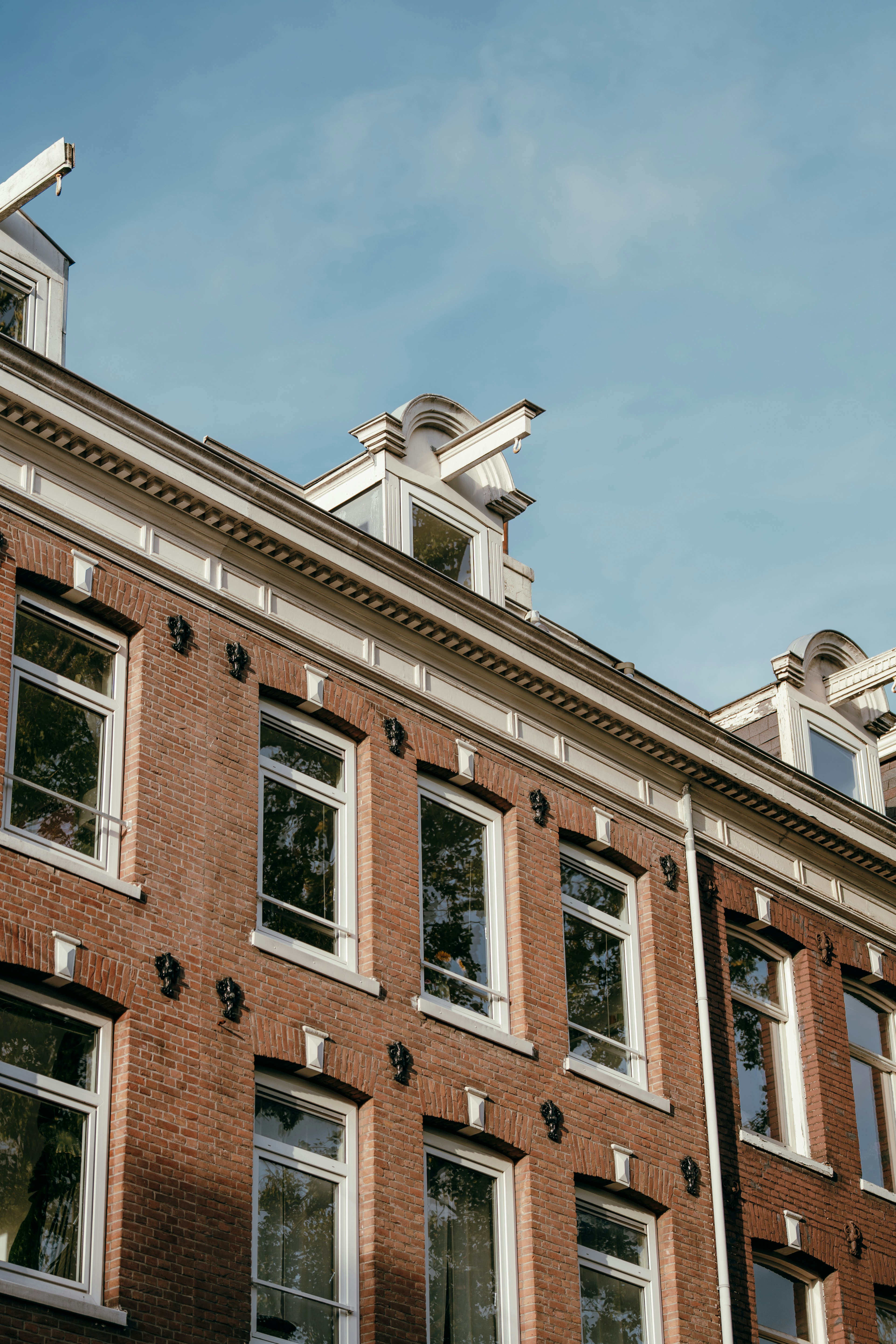 Brick building facade with windows against blue sky.