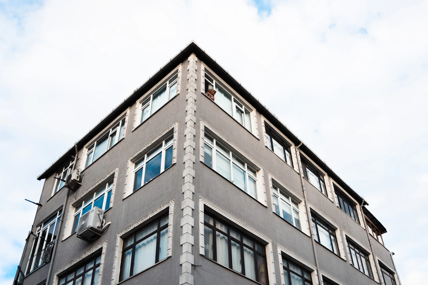 Four-story condominium building against a bright sky
