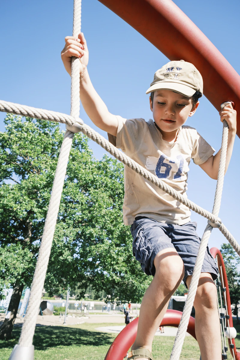 Child climbing on a playground structure, demonstrating body awareness and balance
