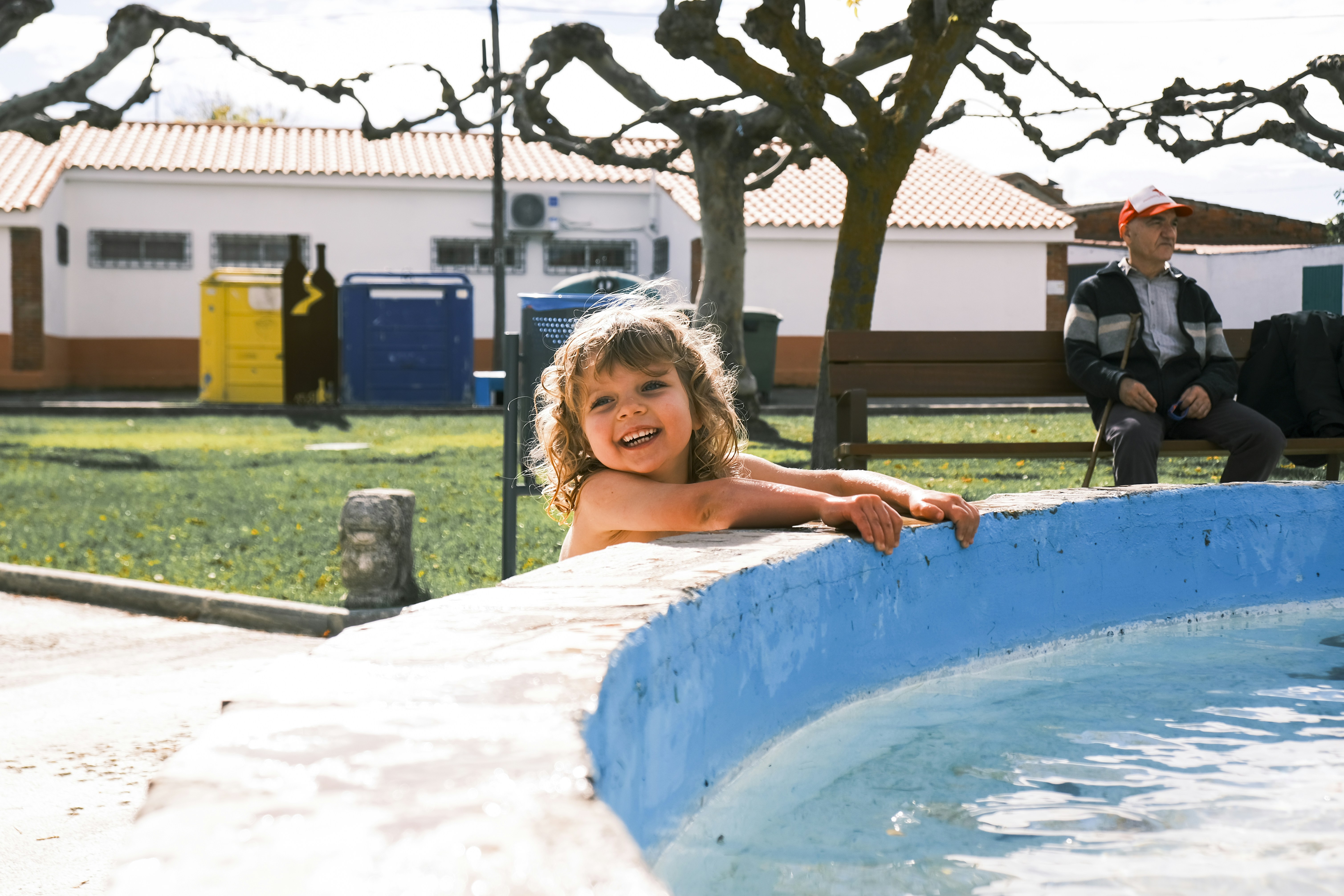 プールの縁から顔をのぞかせる笑顔の子供