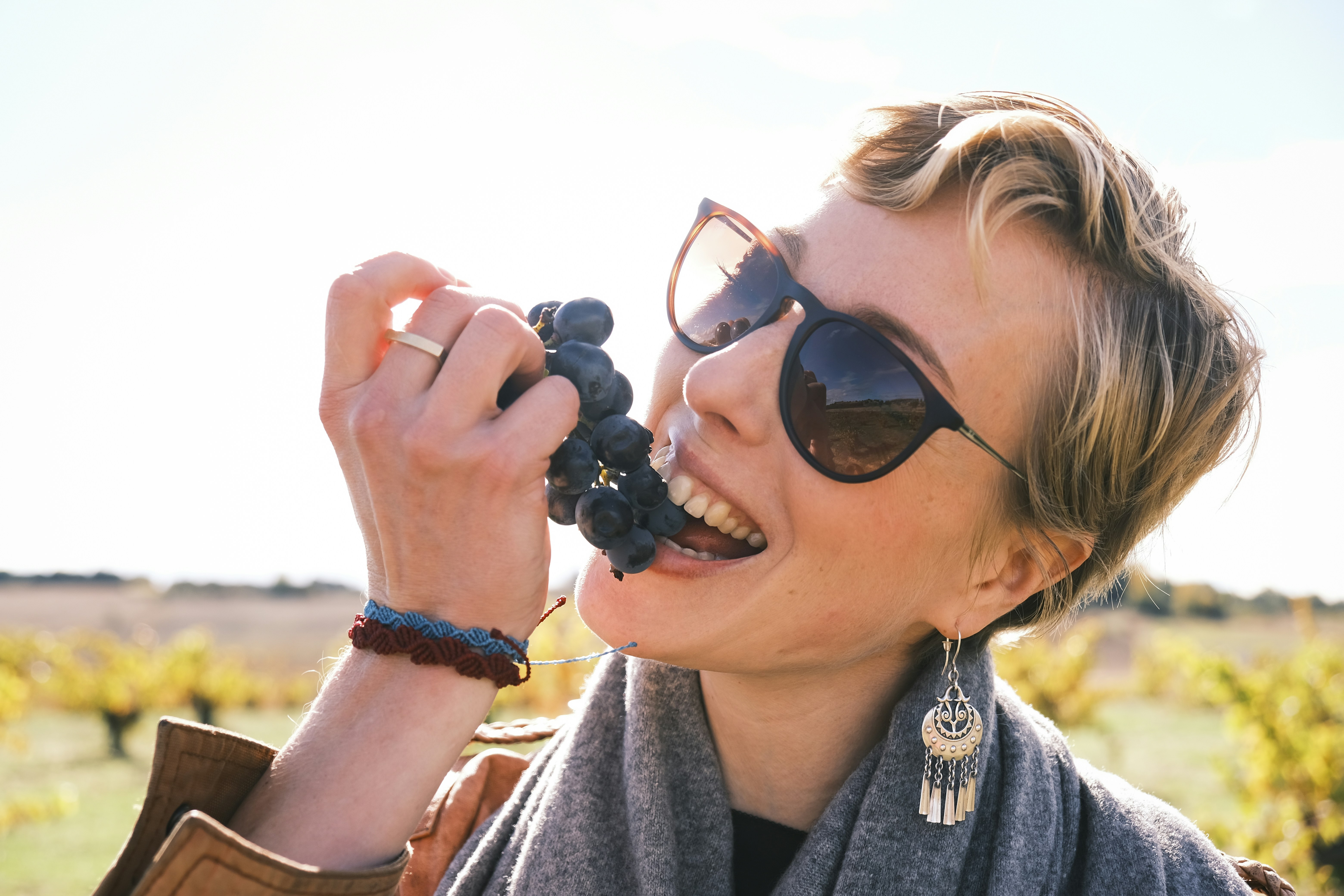 Woman eating grapes in a vineyard