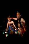 Two dancers in traditional costumes performing on stage.