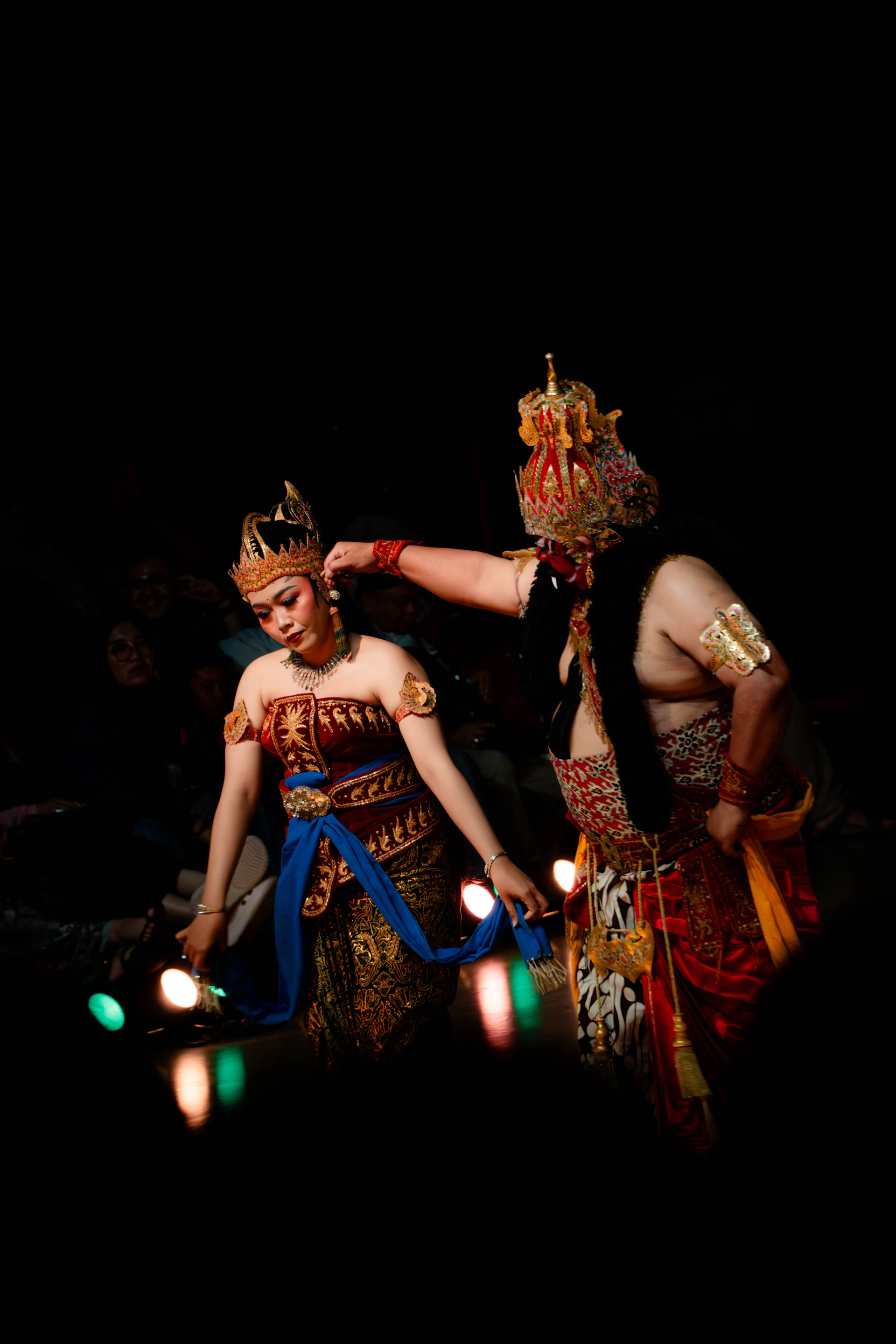 Two dancers in traditional costumes performing on stage.