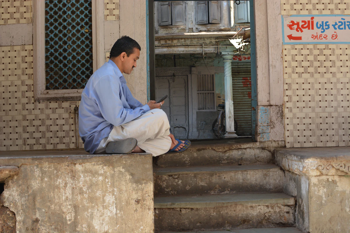 A man sitting on steps checking his phone